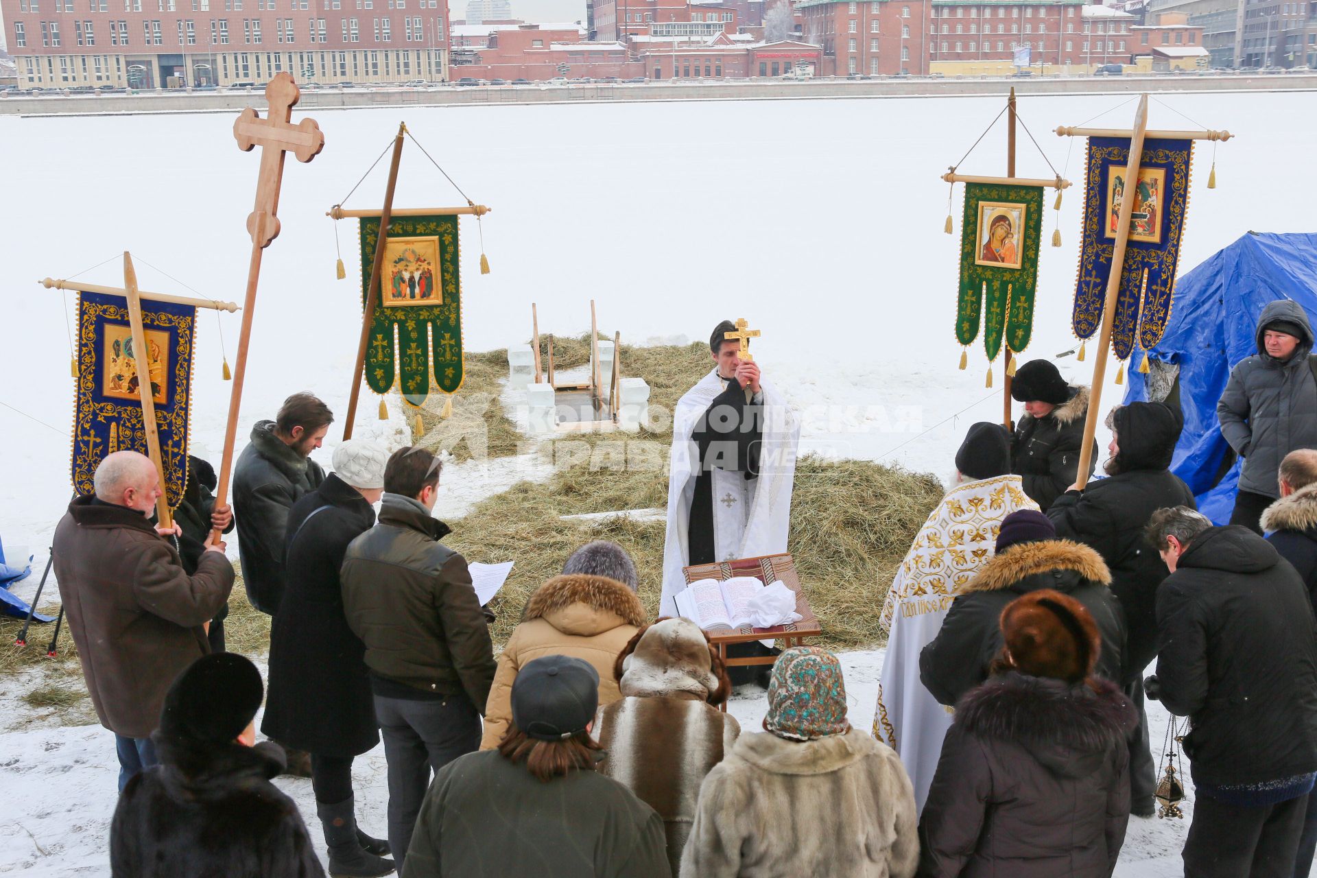 Крещенские купания в Санкт-Петербурге. Священнослужитель освящает прорубь в Неве.