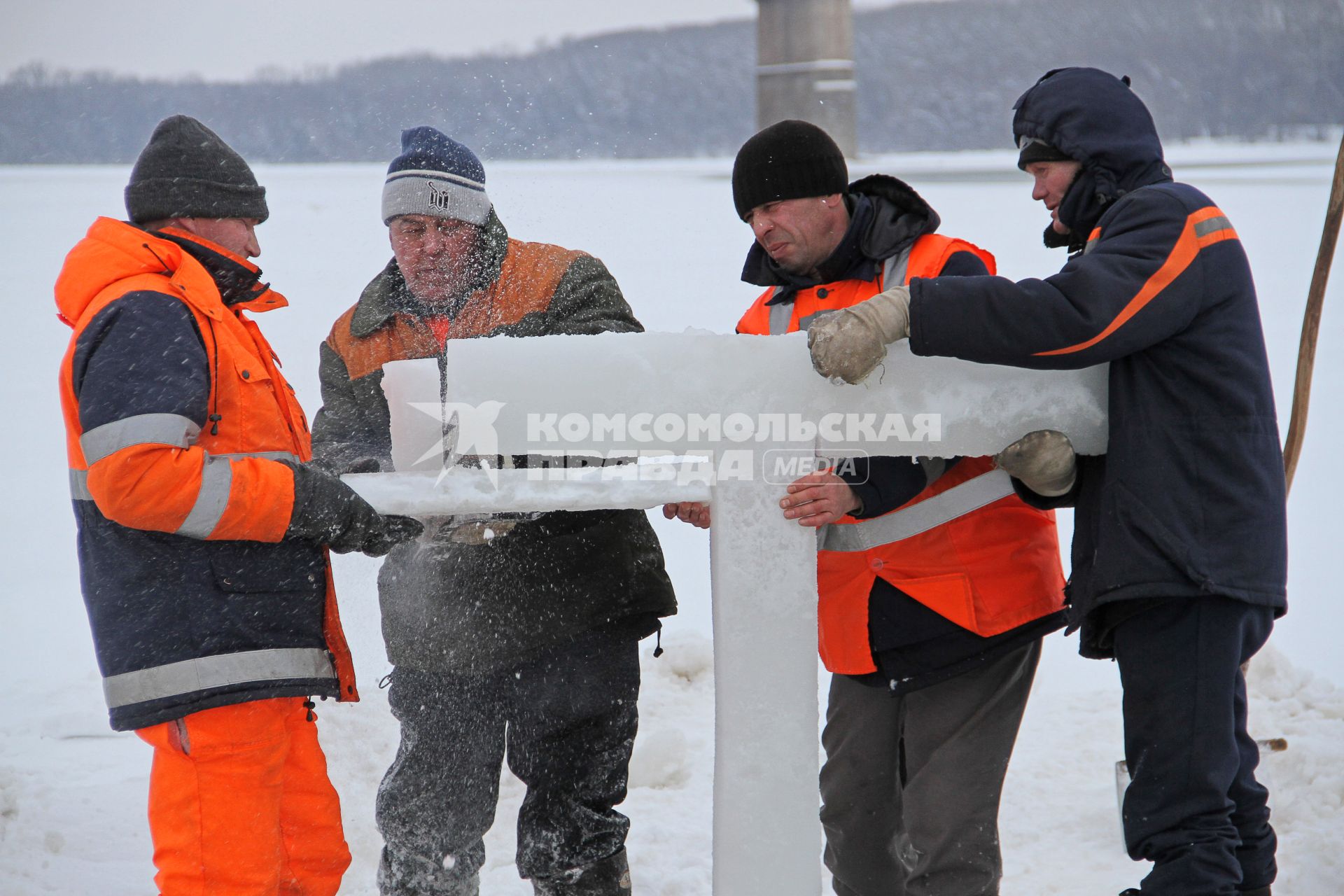 Подготовка к крещенским купаниям в Уфе. Рабочие устанавливают ледяной крест на месте купели в реке.