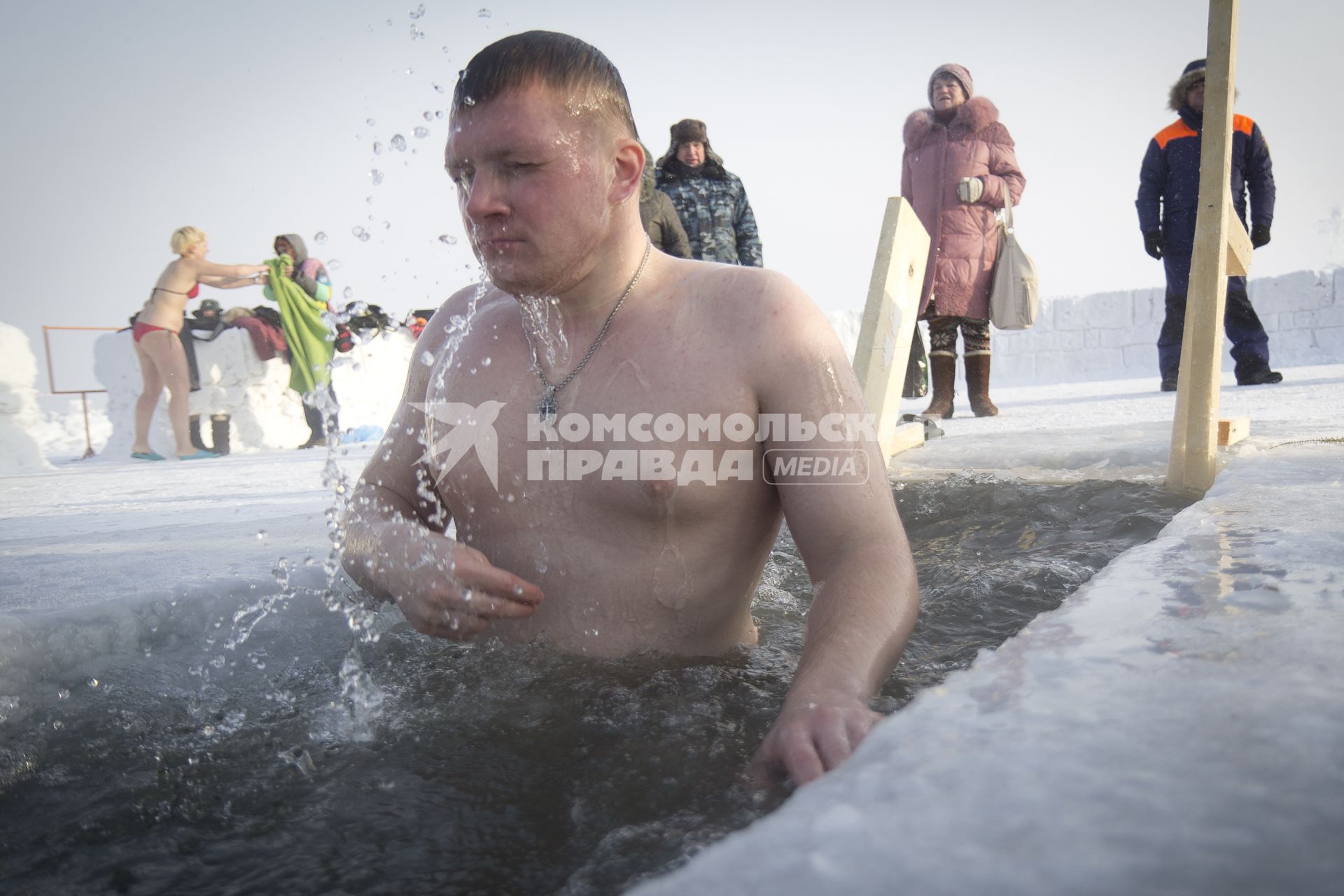 Крещенские купания в Иркутске. Мужчина окунается в проруби.