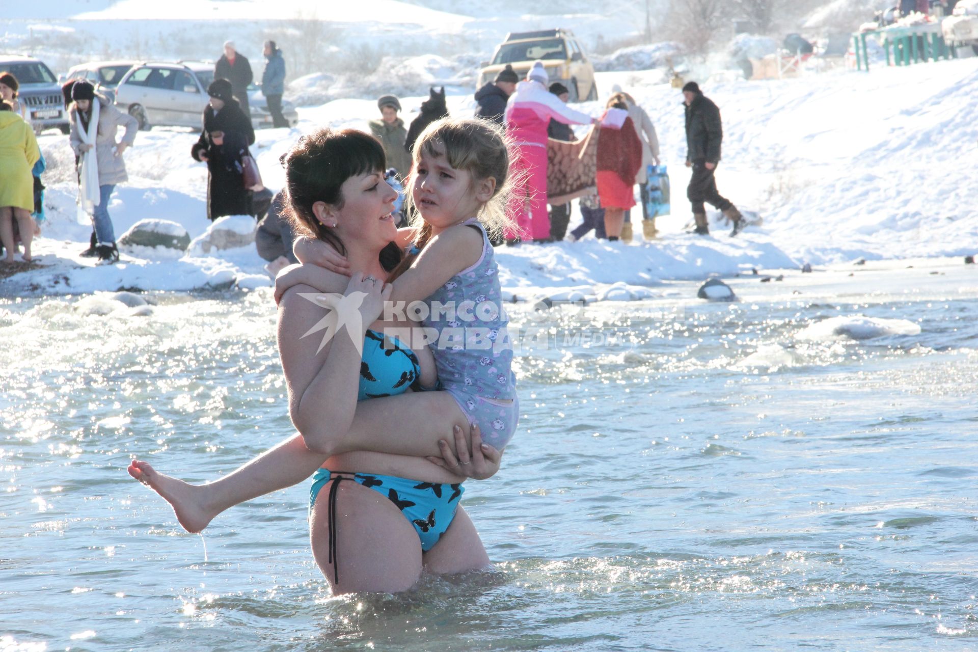Кыргызстан. Крещенские купания в с.Сосновка. Женщина с девочкой заходят в реку Карабалтинка.