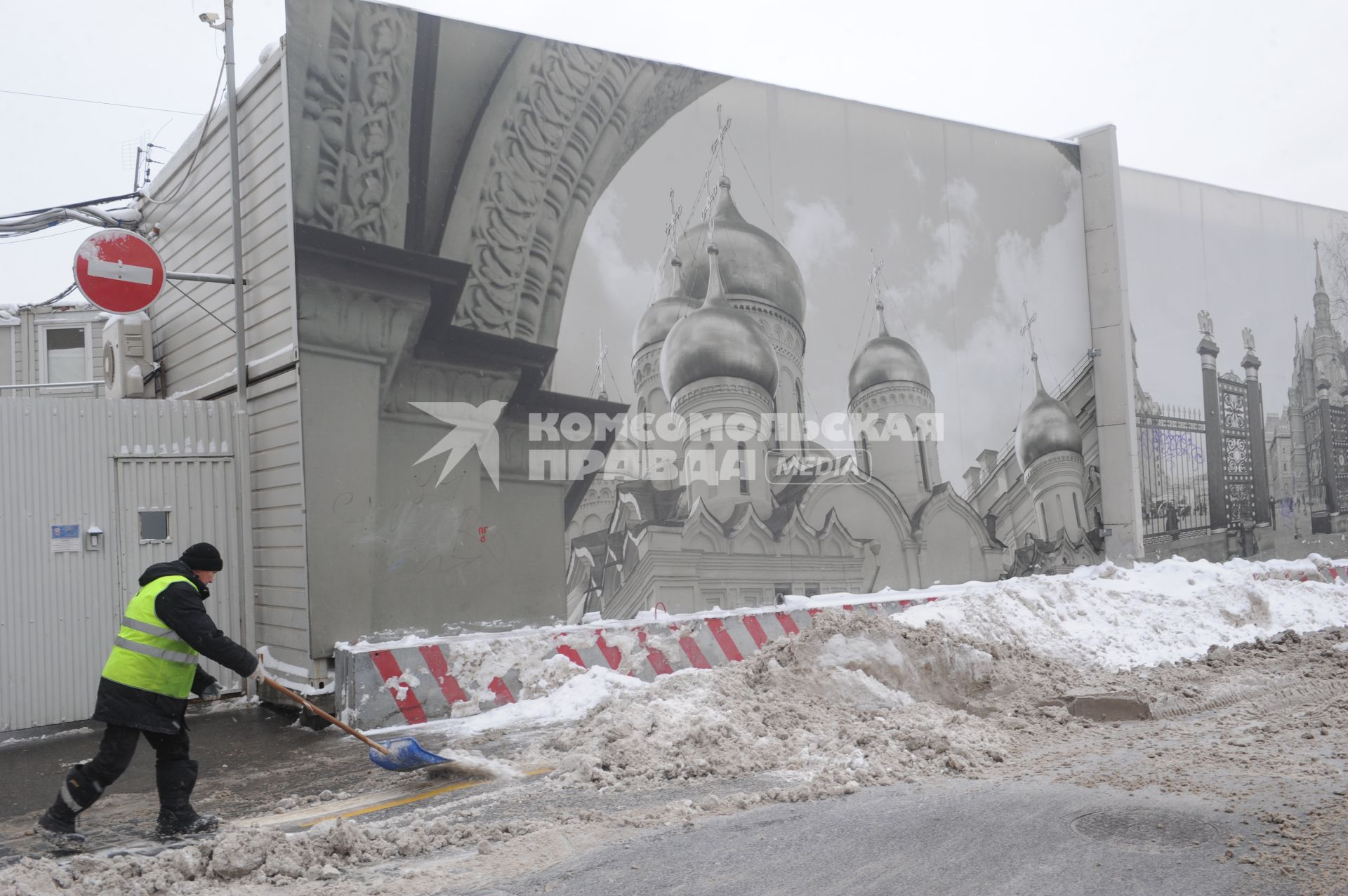 Москва.  Дворник чистит дорогу от снега.