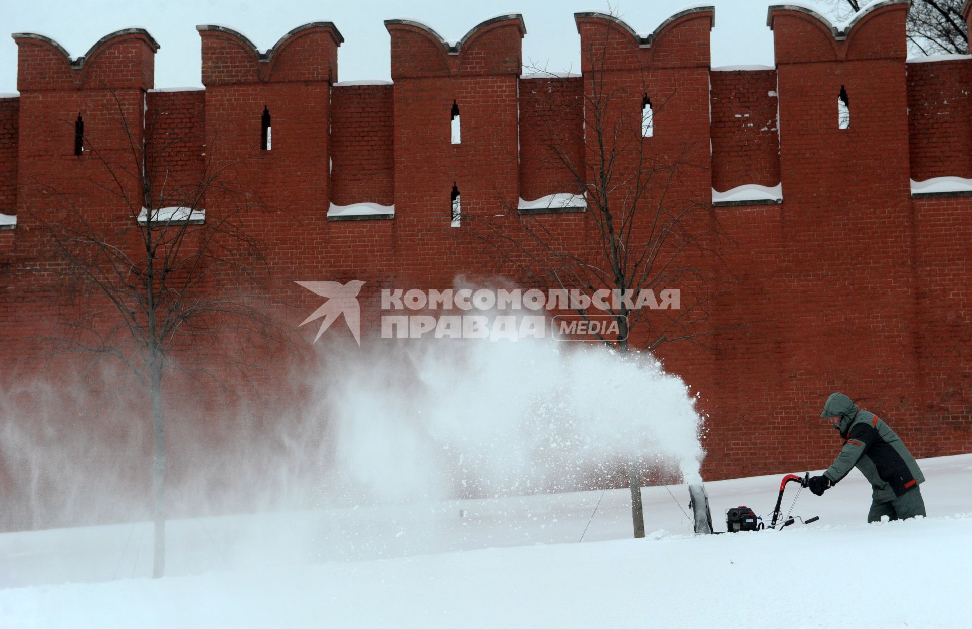 Москва. Сотрудник коммунальной службы  убирает снег   на Красной площади.