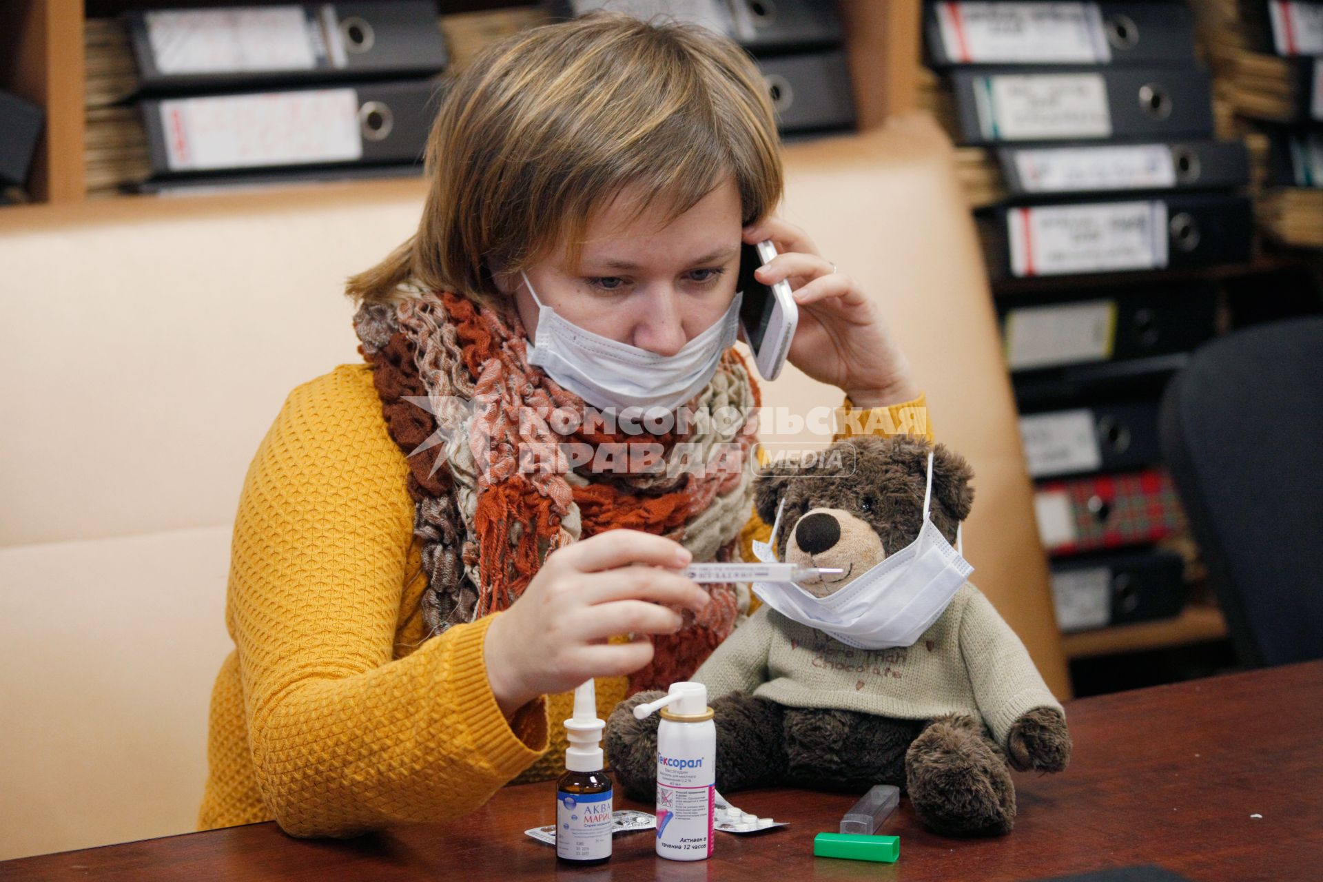 Ярославль. Девушка в маске за столом с медикаментами меряет температуру.