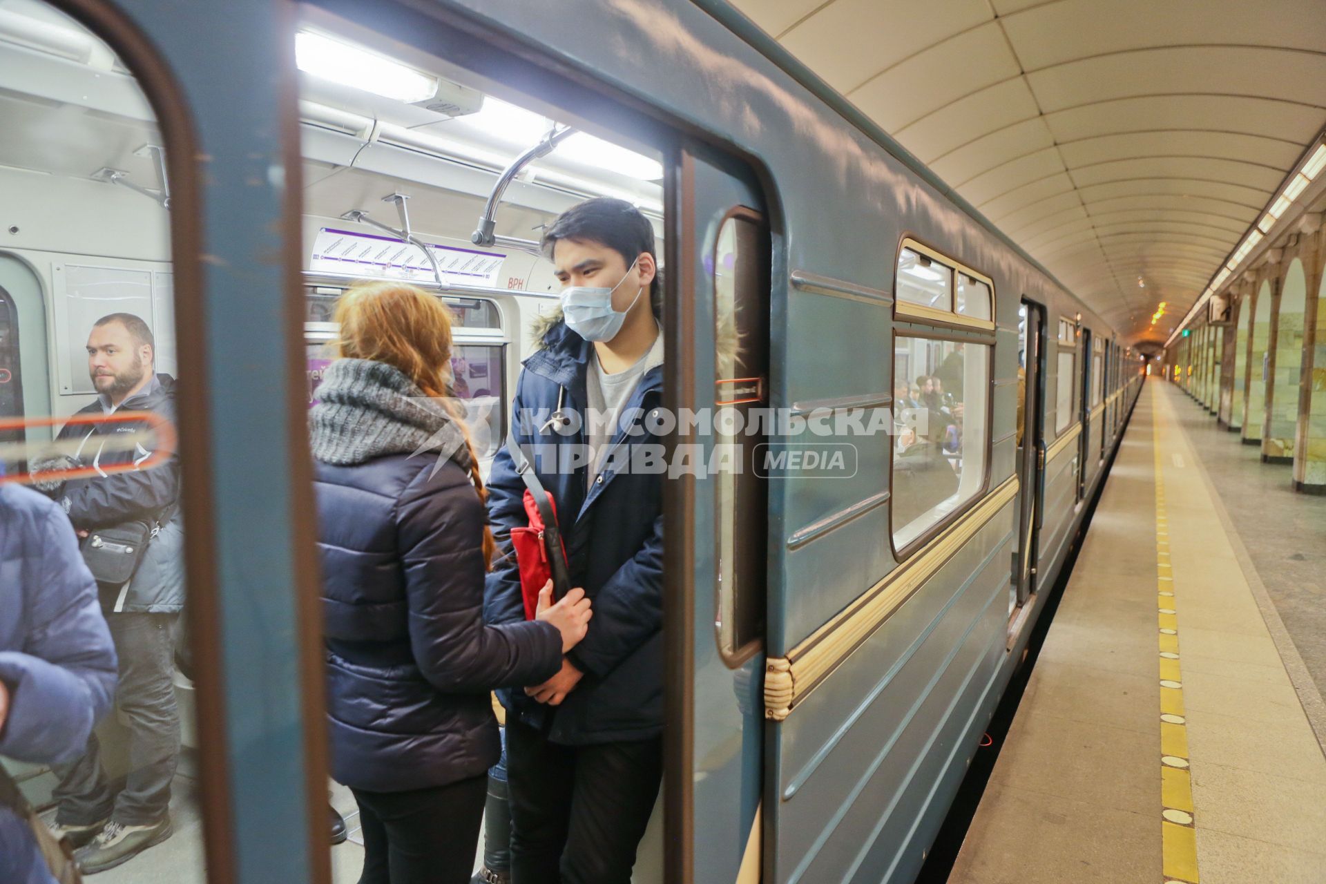 Санкт-Петербург. Молодые люди в медицинских масках в вагоне поезда.