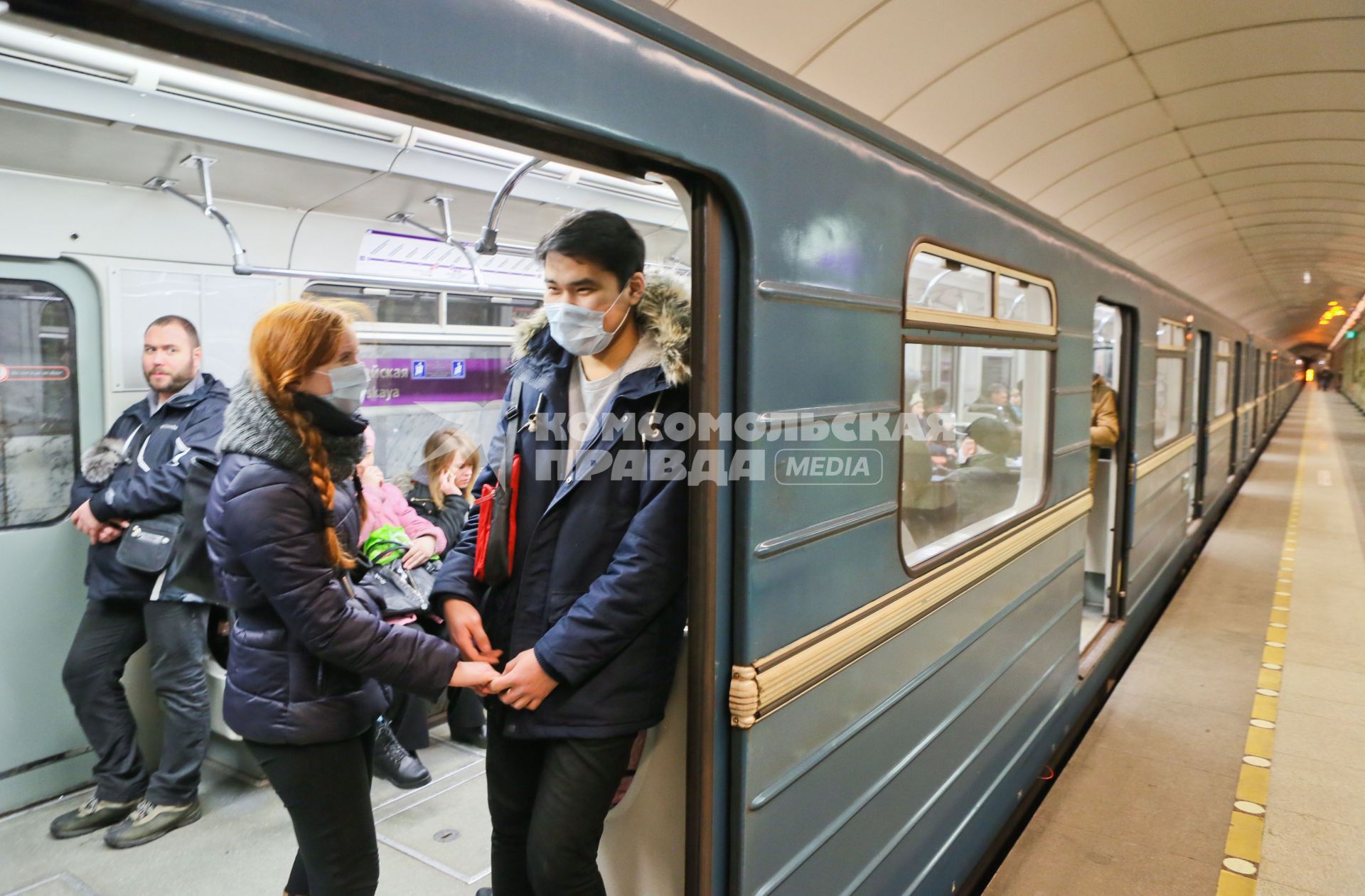 Санкт-Петербург. Молодые люди в медицинских масках в вагоне поезда.
