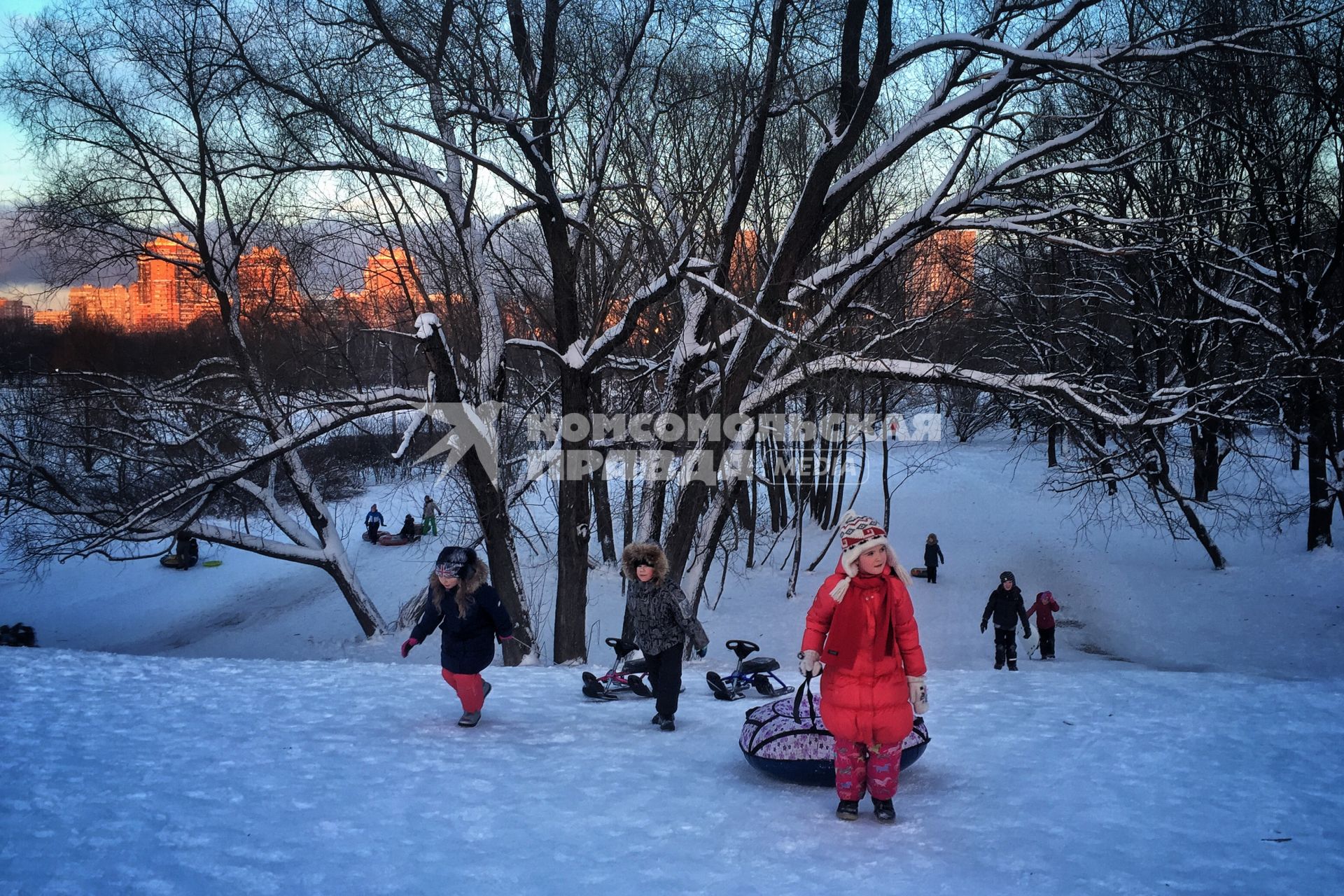 Москва.   Дети катаются с горки в парке Дружбы.