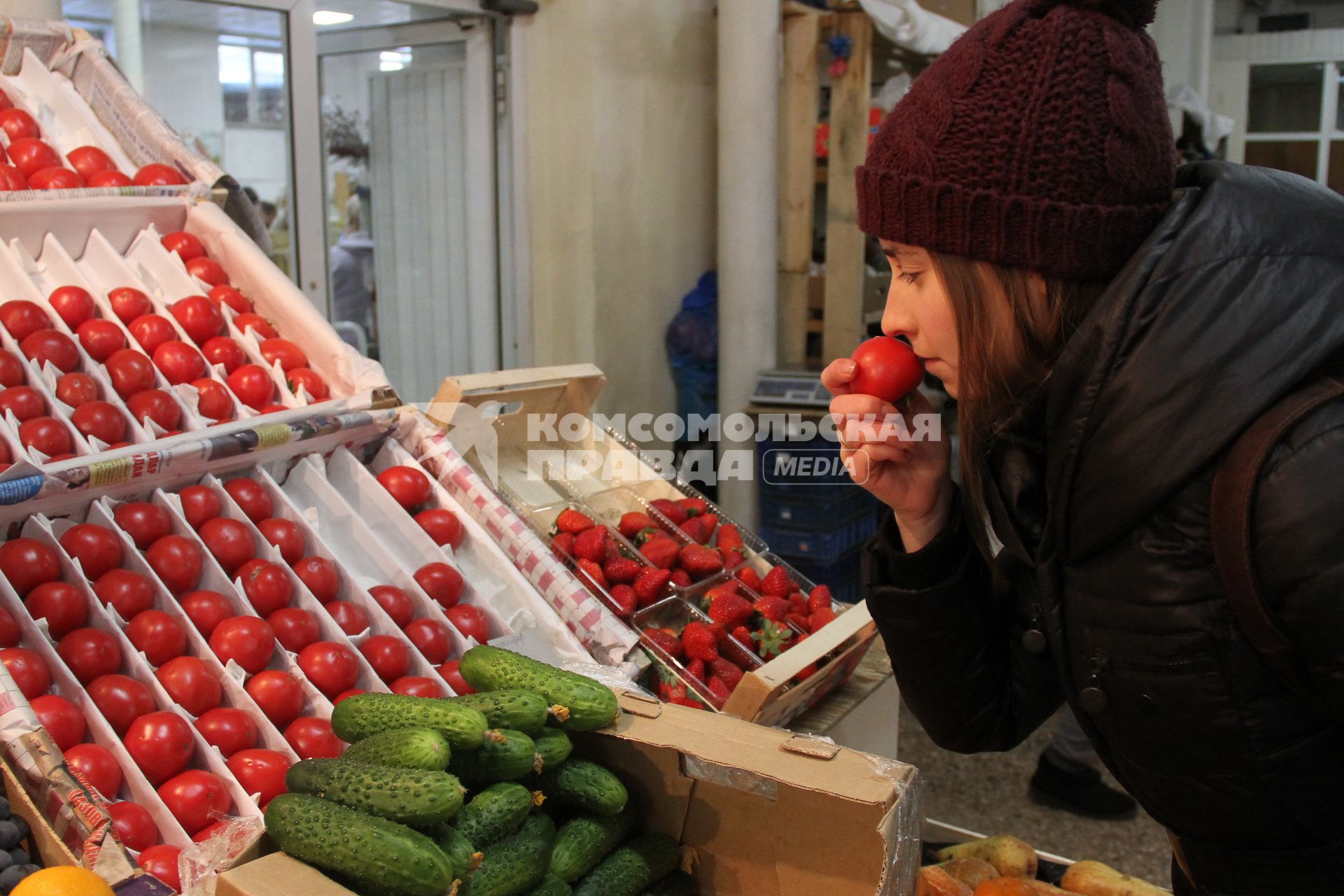 Нижний Новгород. Девушка выбирает помидоры на рынке.