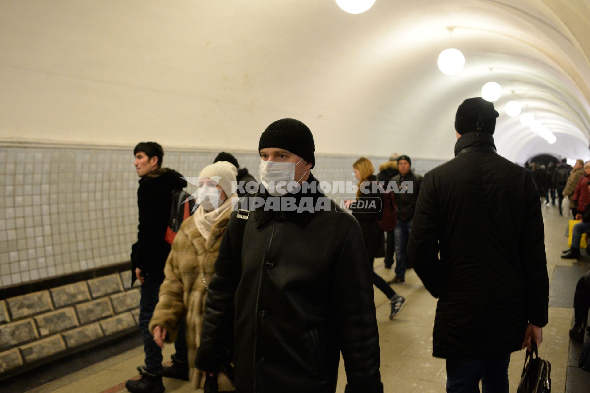Эпидемия свиного гриппа в Москве. Мужчина и женщина в медицинский масках идут по перрону метро.