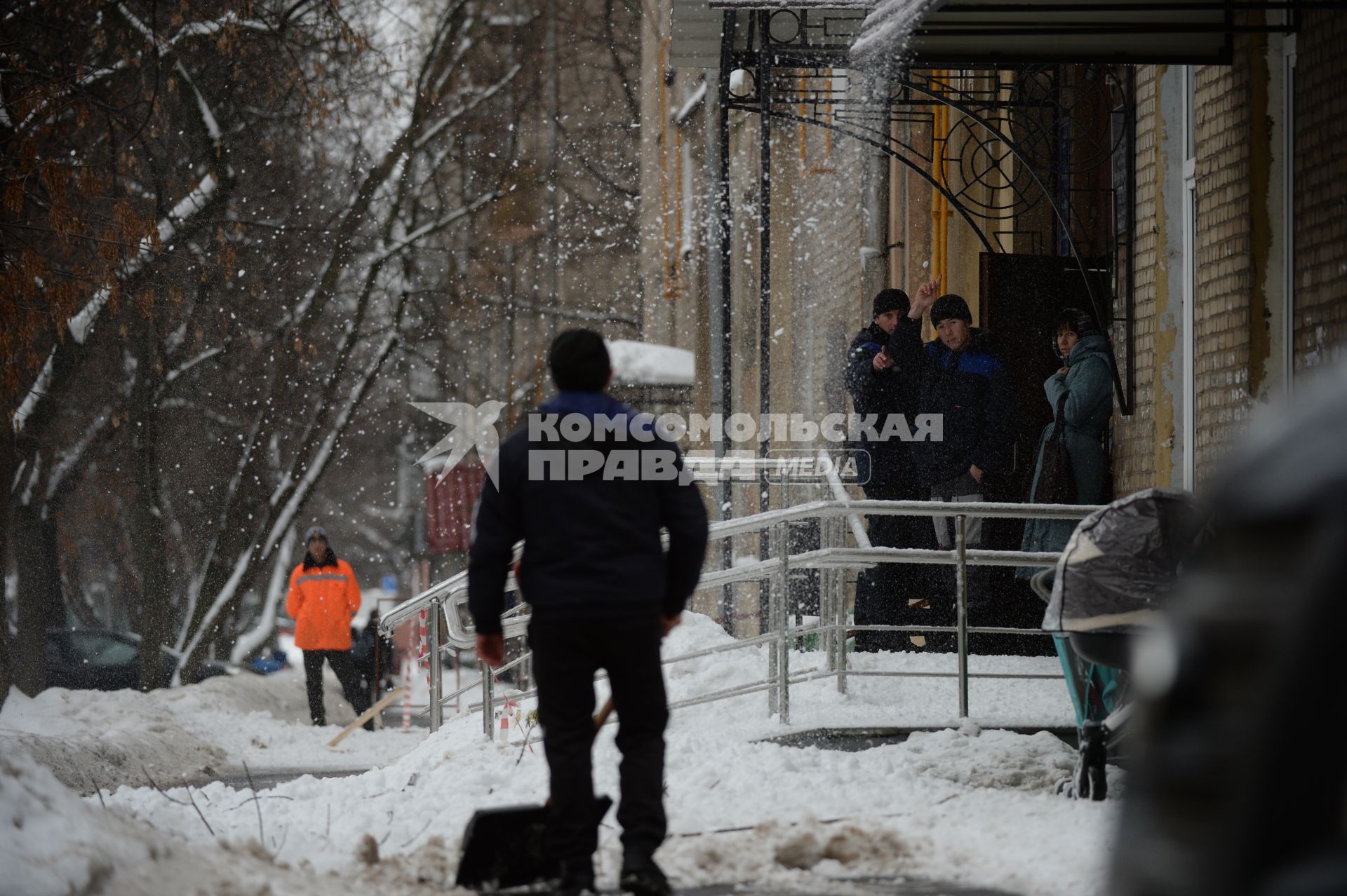 Москва.  Дворники чистят снег на одной из улиц города.