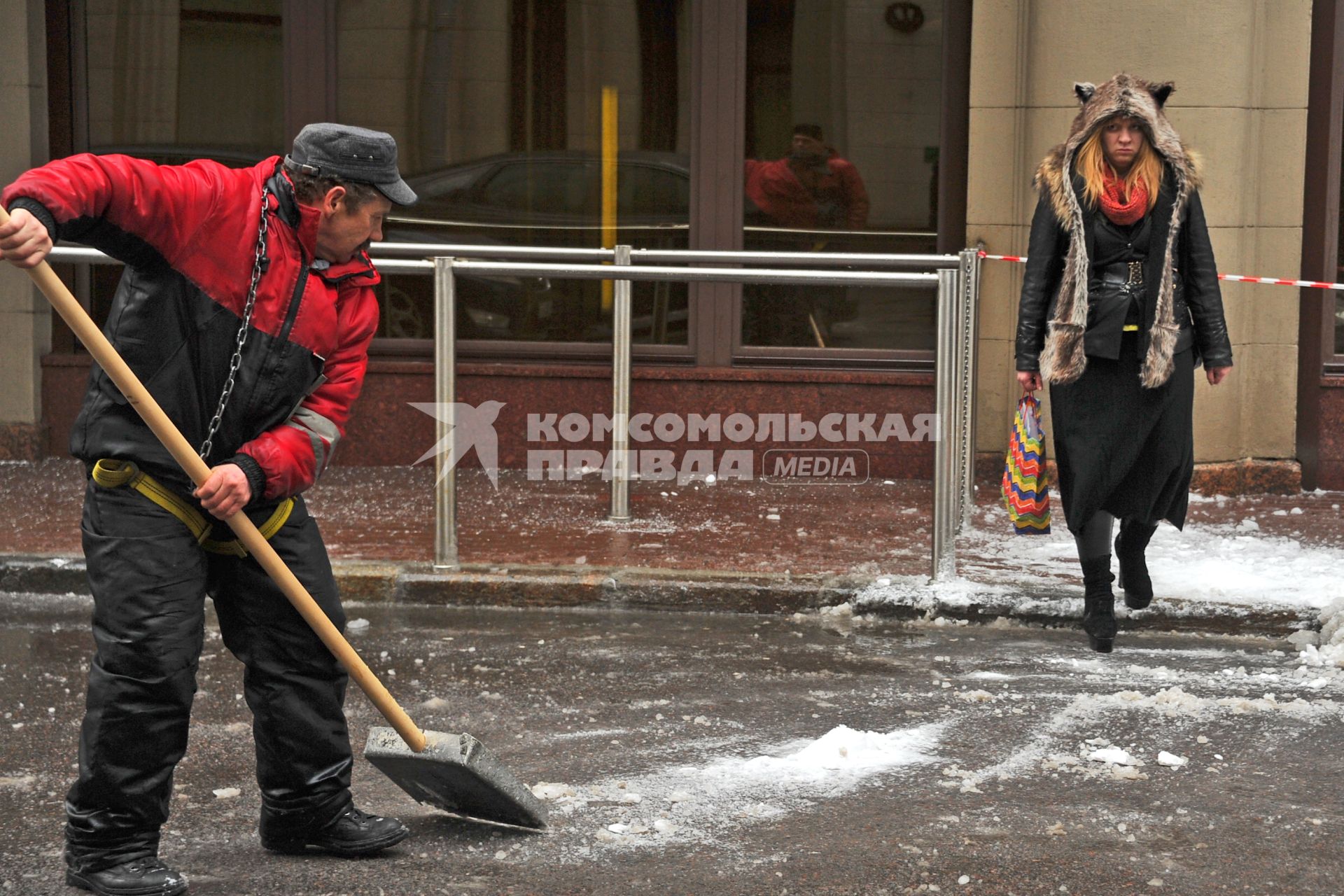 Москва.  Работник  коммунальной службы убирает снег на улице.