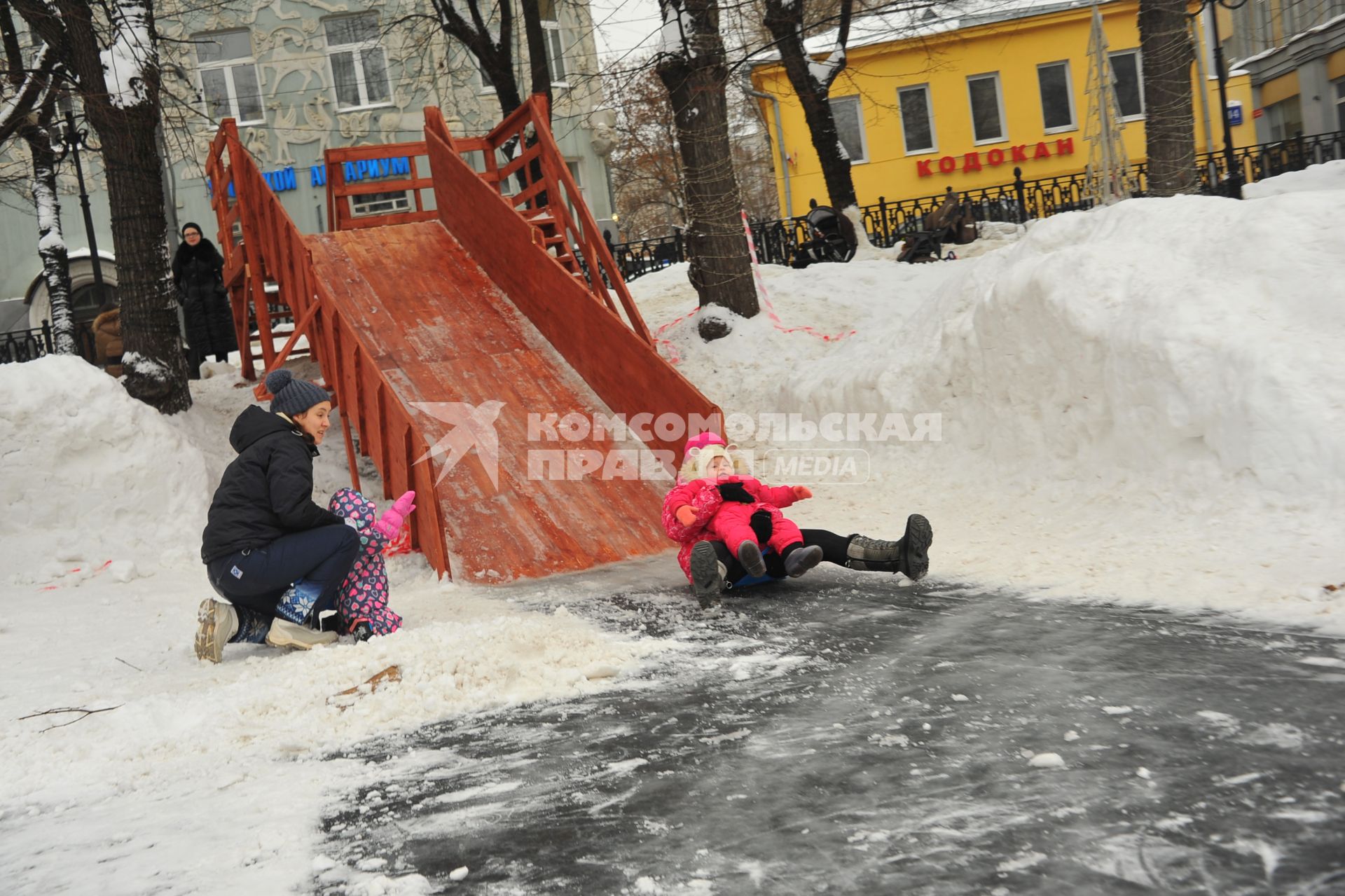 Москва.  Дети катаются с горки.