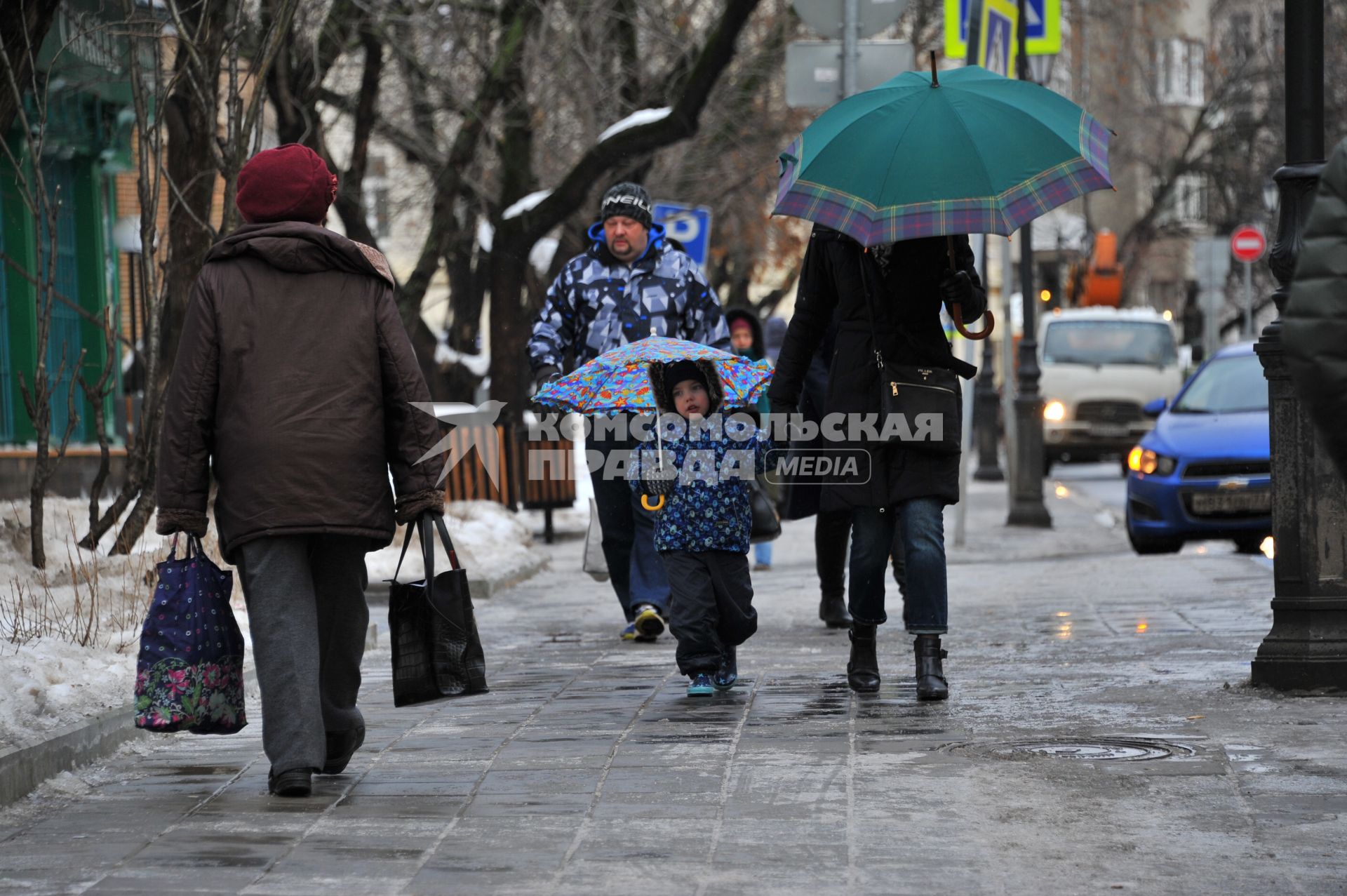 Москва.   Мама с ребенком под зонтиками.