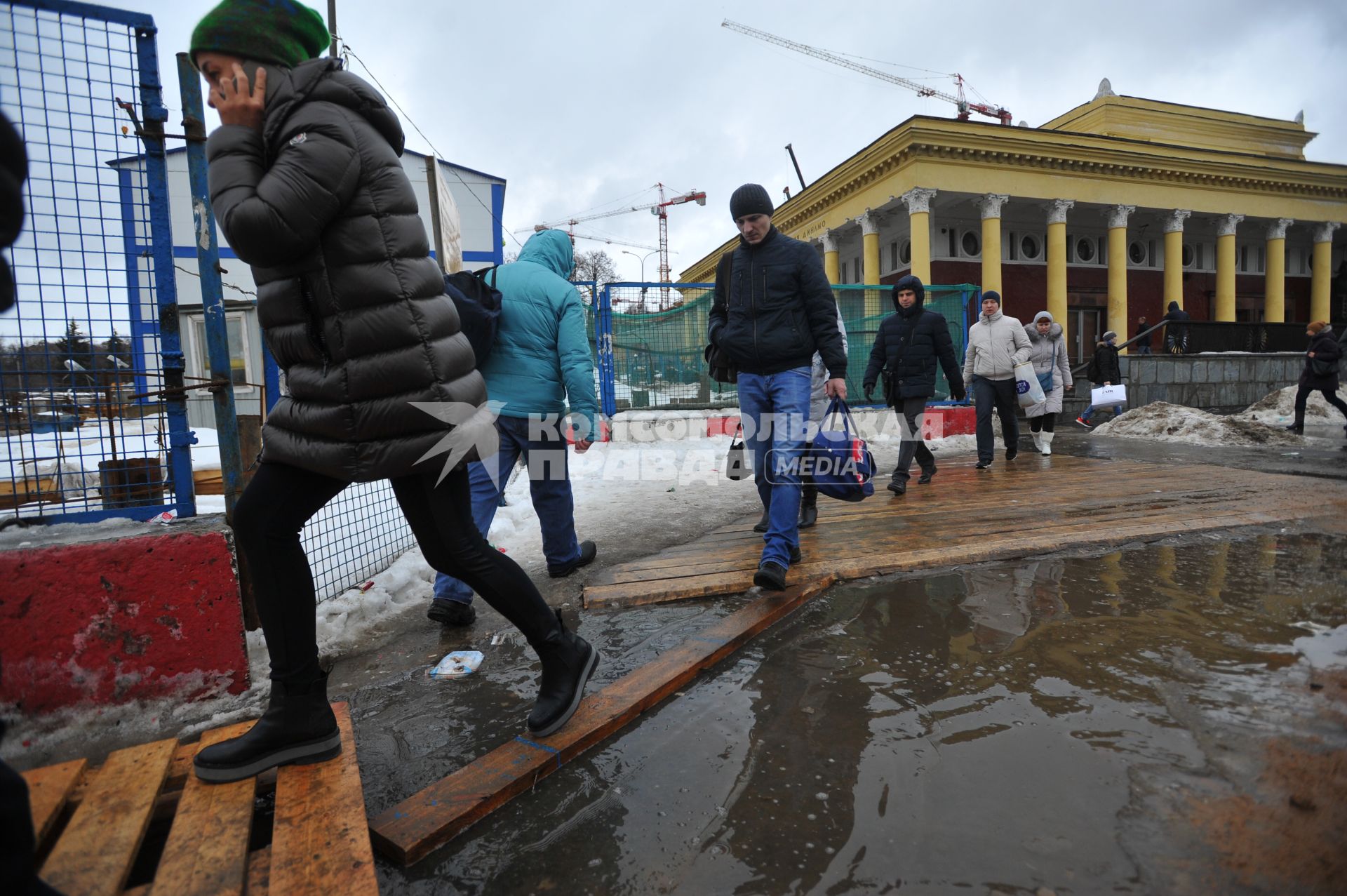 Москва.    Прохожие обходят лужи у станции метро `Динамо`.