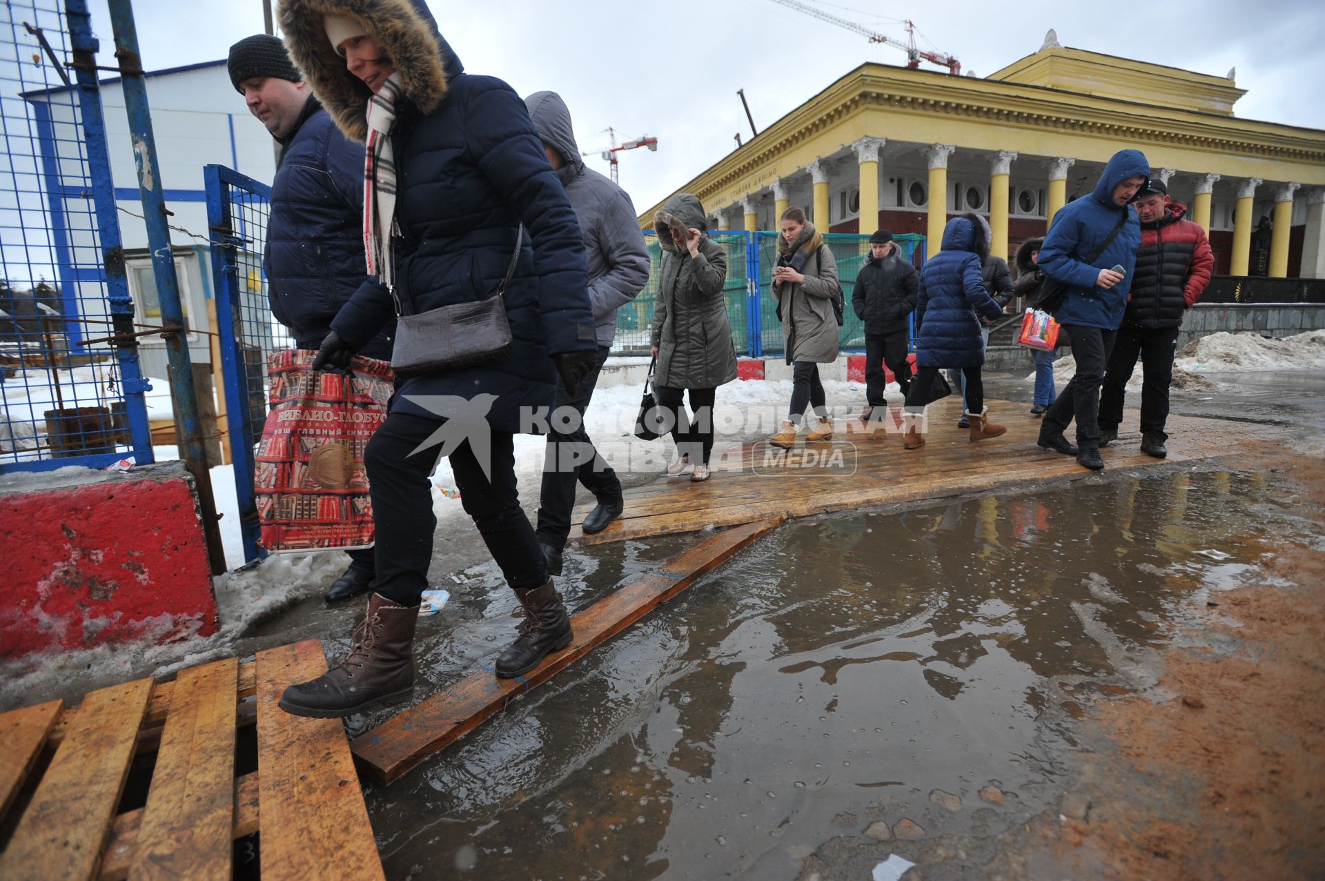 Москва.    Прохожие обходят лужи у станции метро `Динамо`.