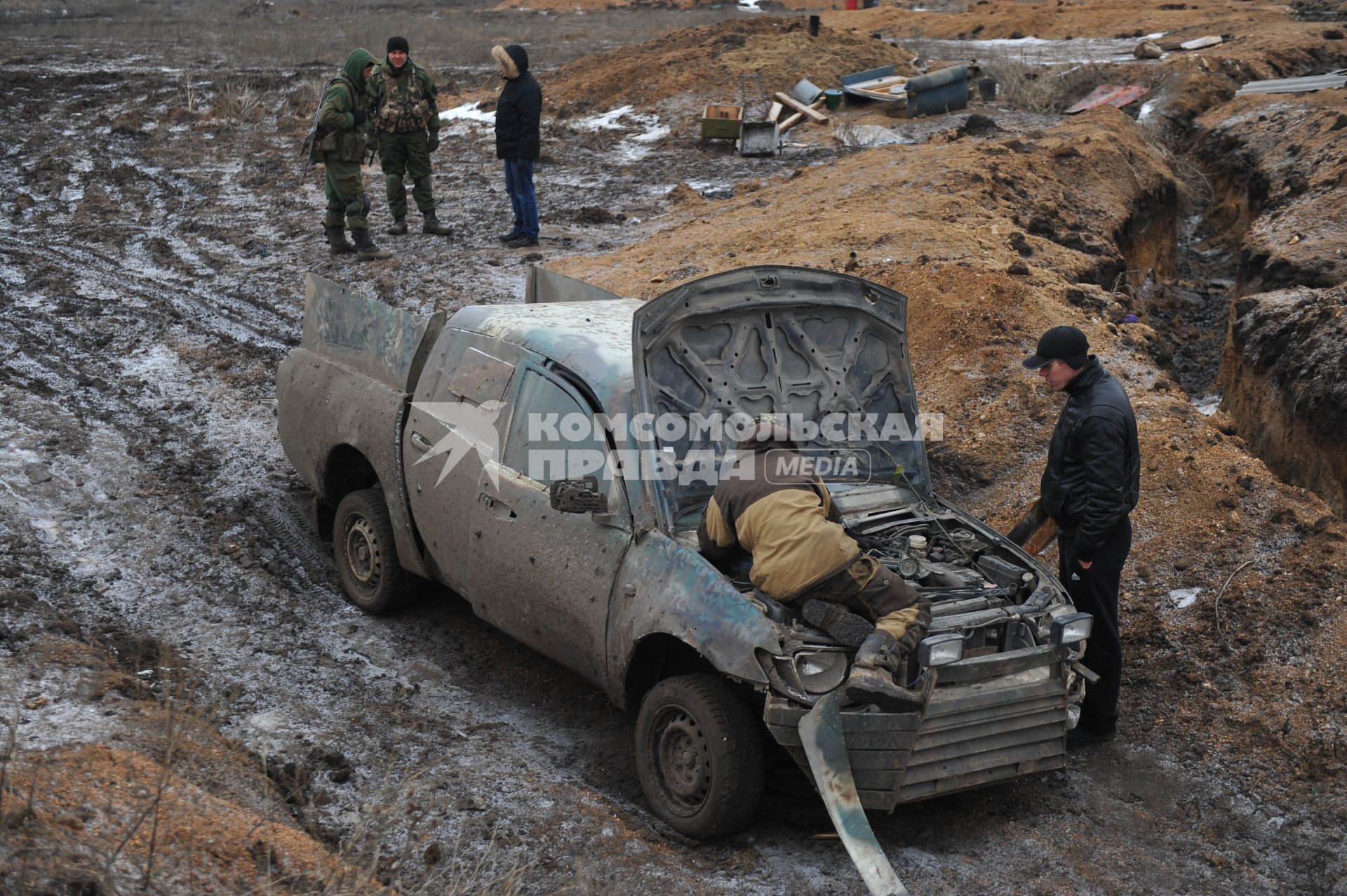 Украина. Донецкая область. Ополченцы, бойцы отряда `Викинг` чинят автомобиль рядом с боевыми позициями.