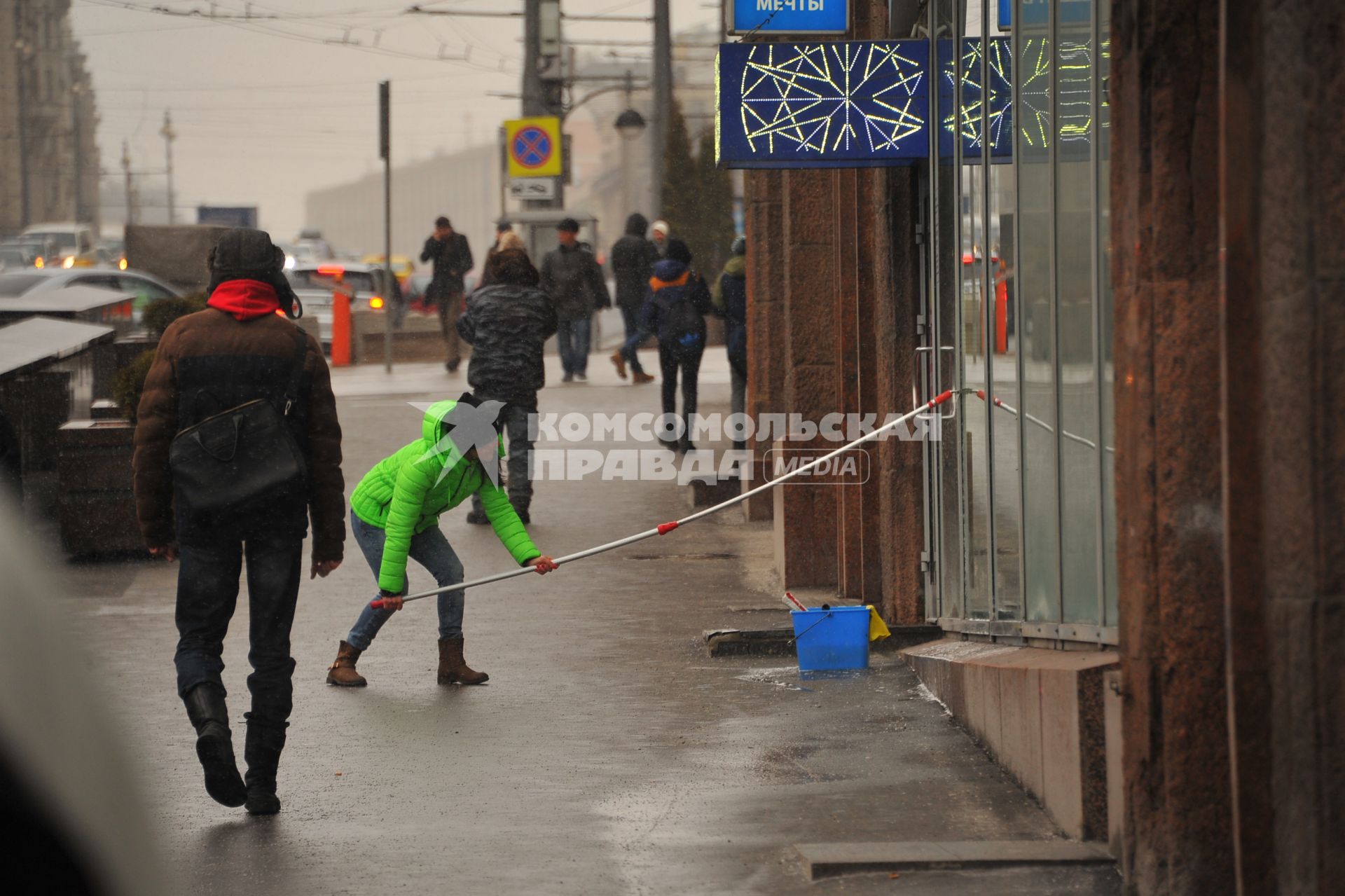 Москва.  Девушка моет витрину.