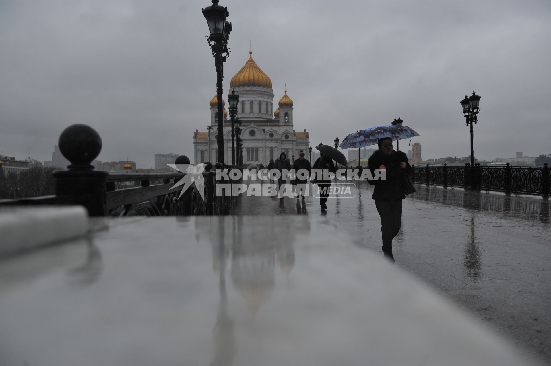 Москва.  Прохожие идут по  Патриаршему мосту  во время дождя.