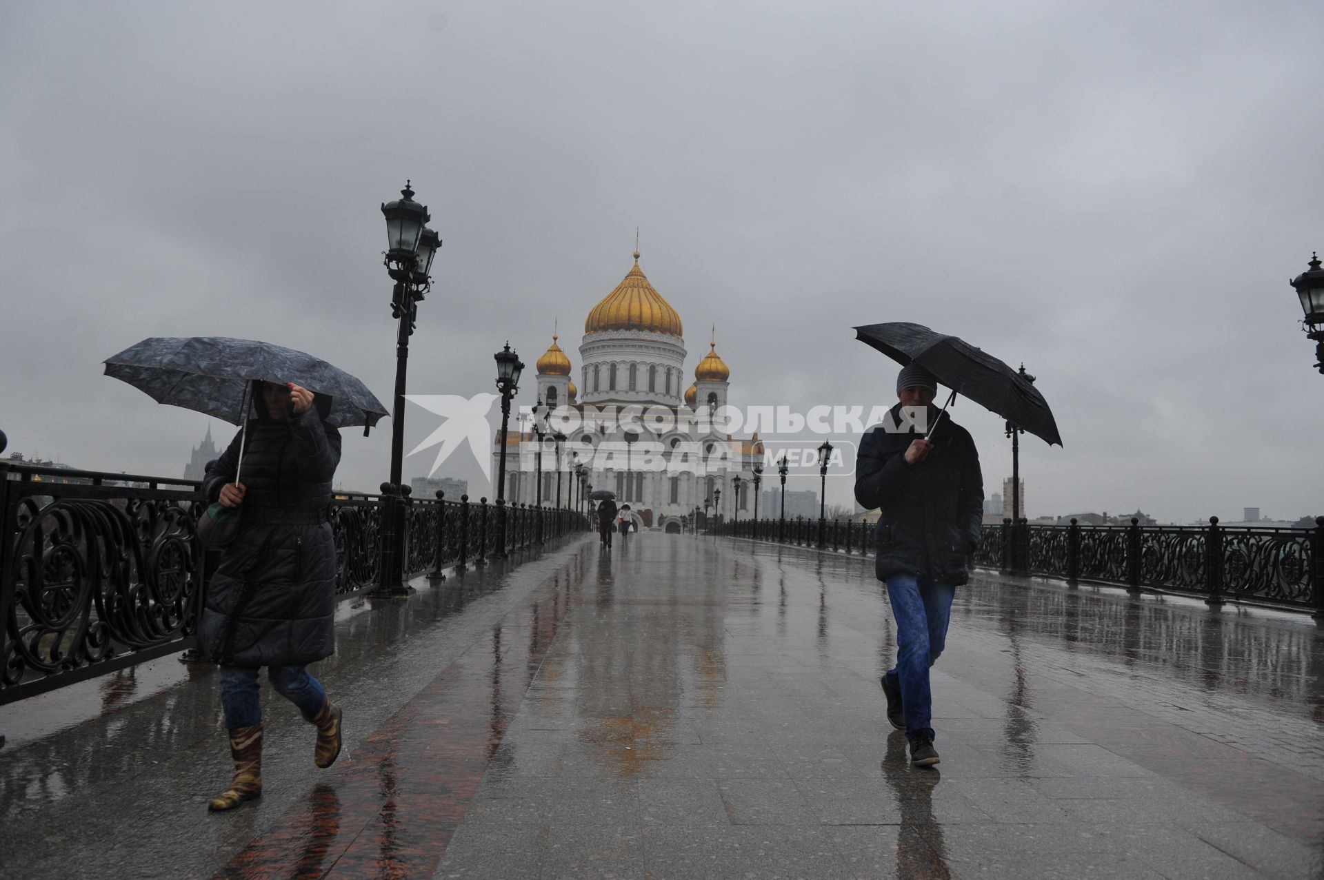 Москва.  Прохожие идут по  Патриаршему мосту  во время дождя.