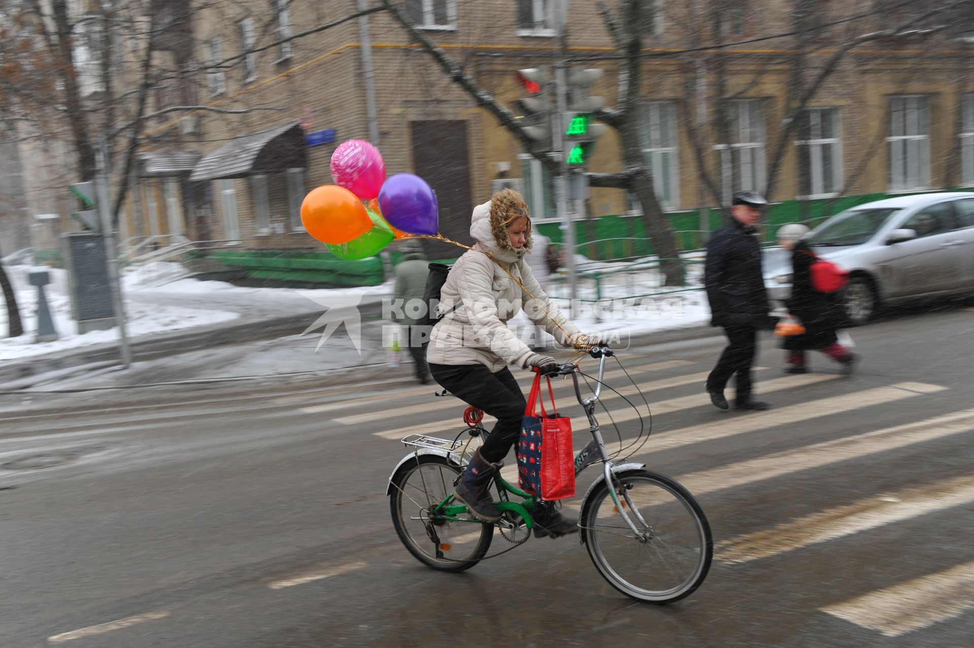 Москва.  Женщина едет на велосипеде по дороге.