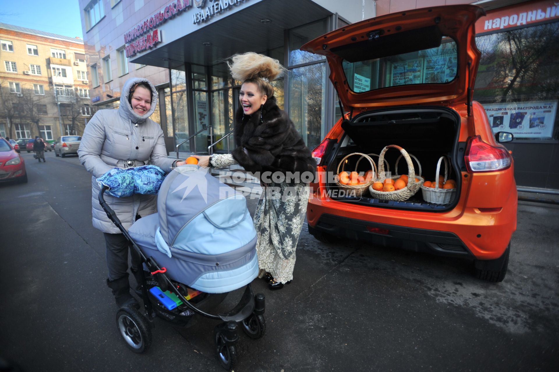 Москва. Писательница Лена Ленина угощает прохожих апельсинами возле редакции `Комсомольской правды`.