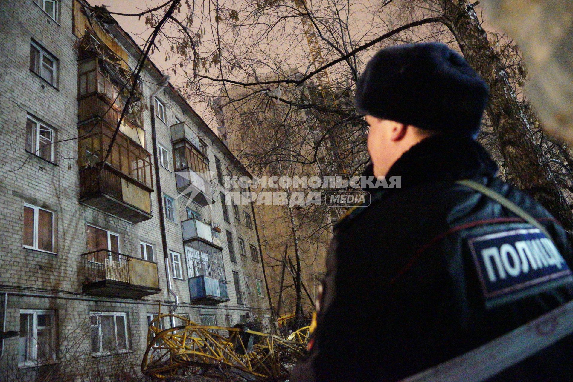 Екатеринбург. Сотрудник полиции на месте падения строительного крана на жилой дом.