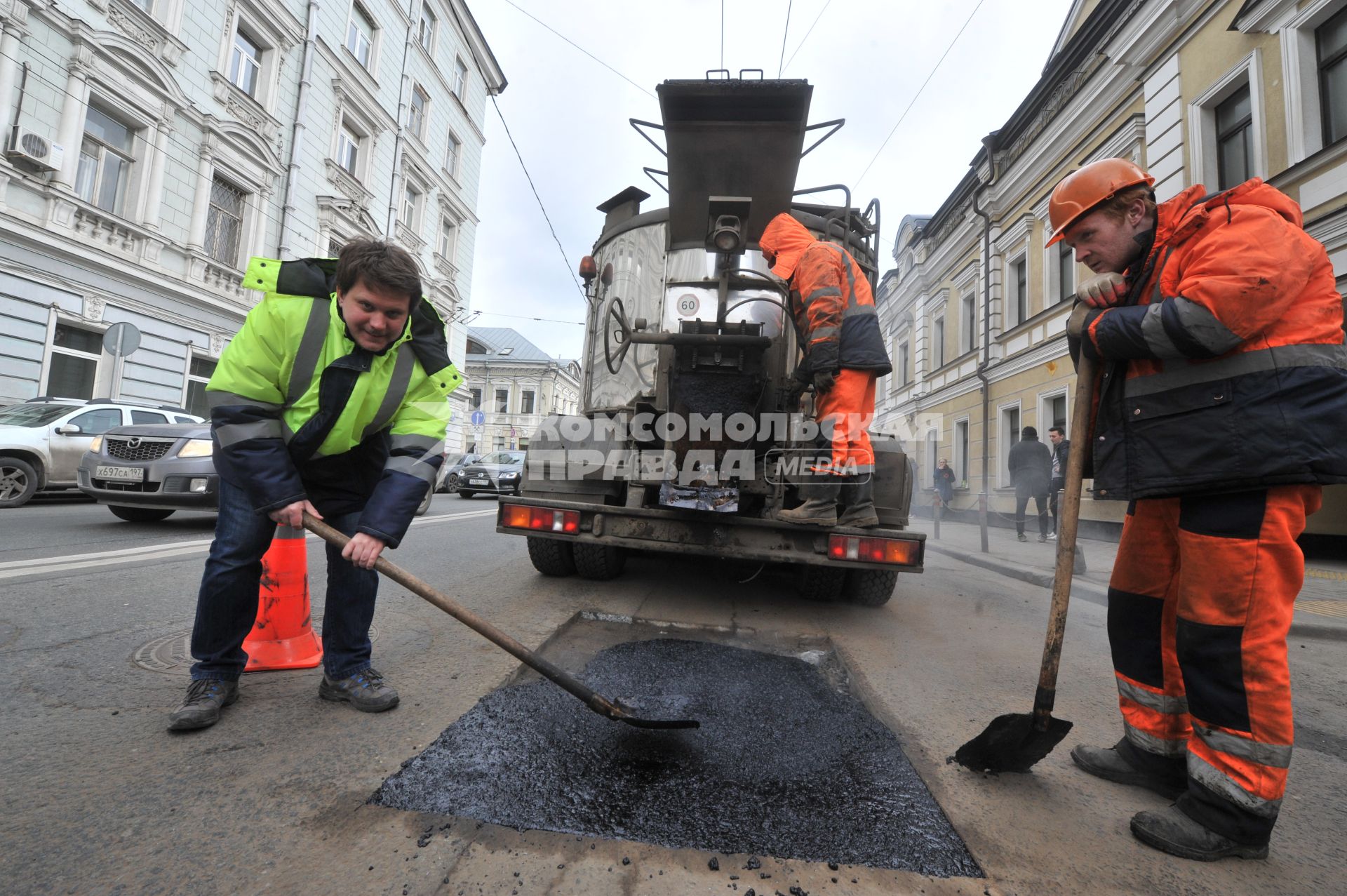 Москва.  Корреспондент `Комсомольской правды` Олег Адамович (слева) во время выполнения работ по ямочному ремонту дорог  на улице Николоямская.