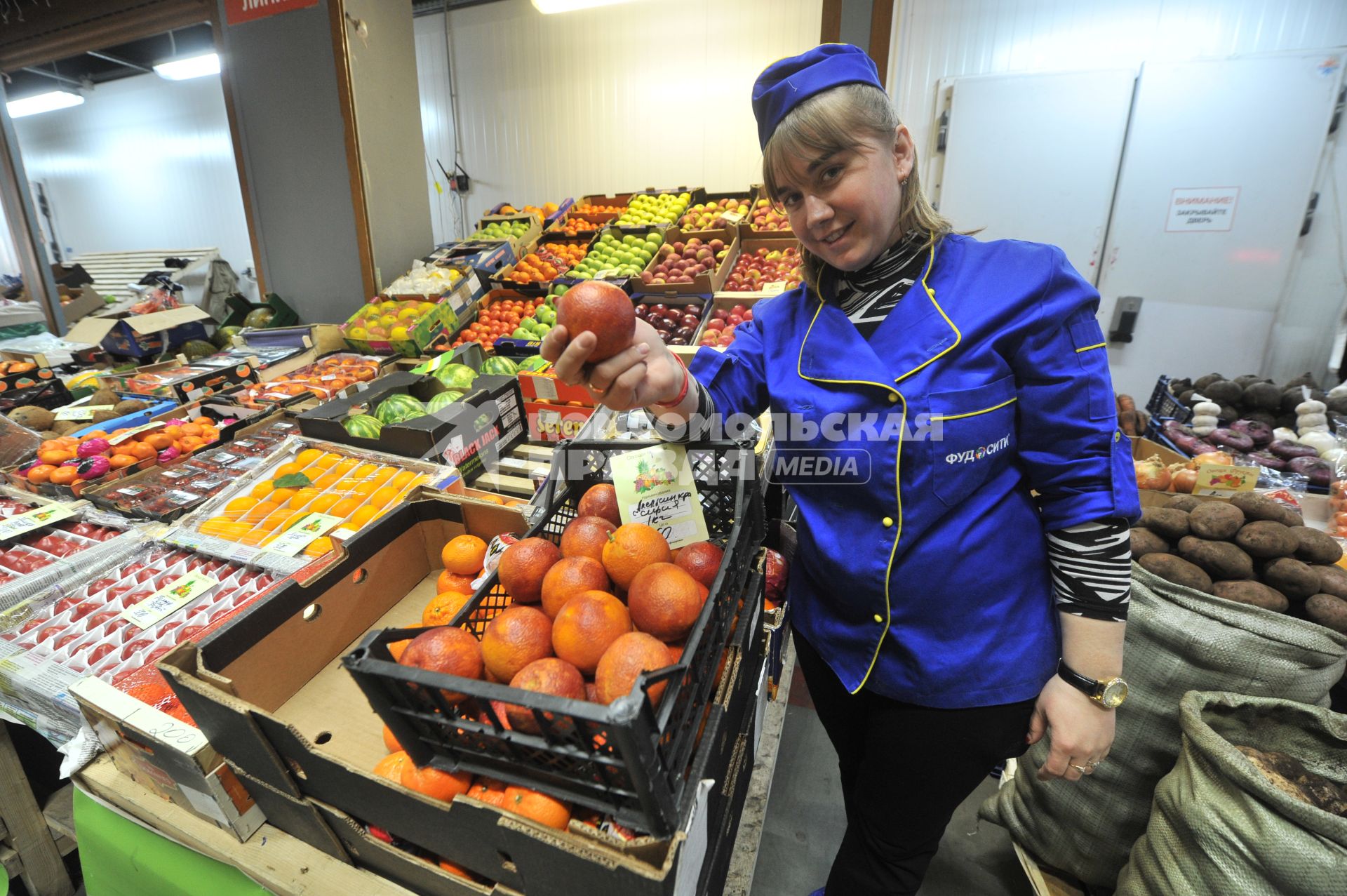 Москва.  Девушка продавец у лотка с сирийскими апельсинами.