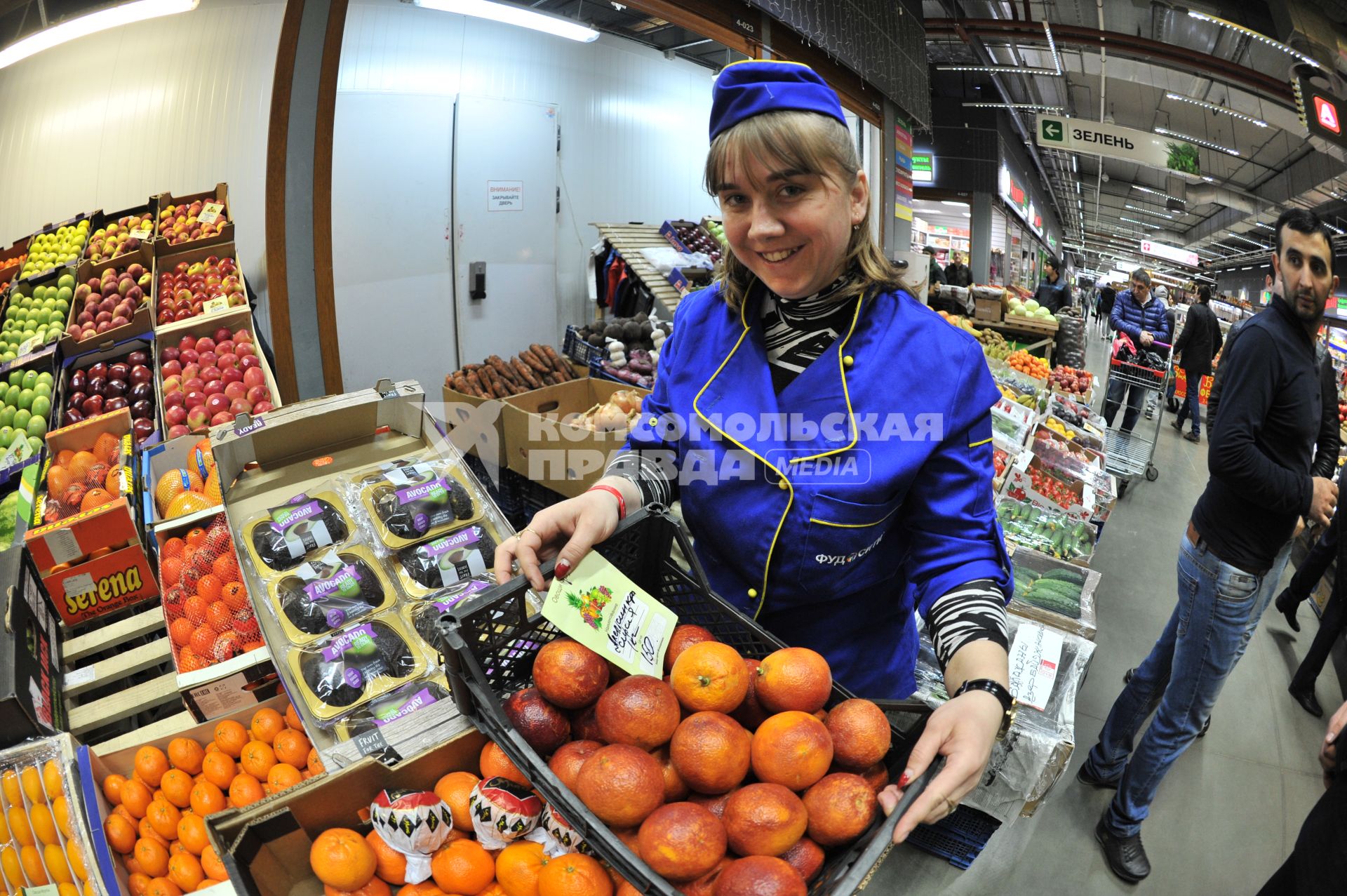 Москва.  Девушка продавец у лотка с сирийскими апельсинами.