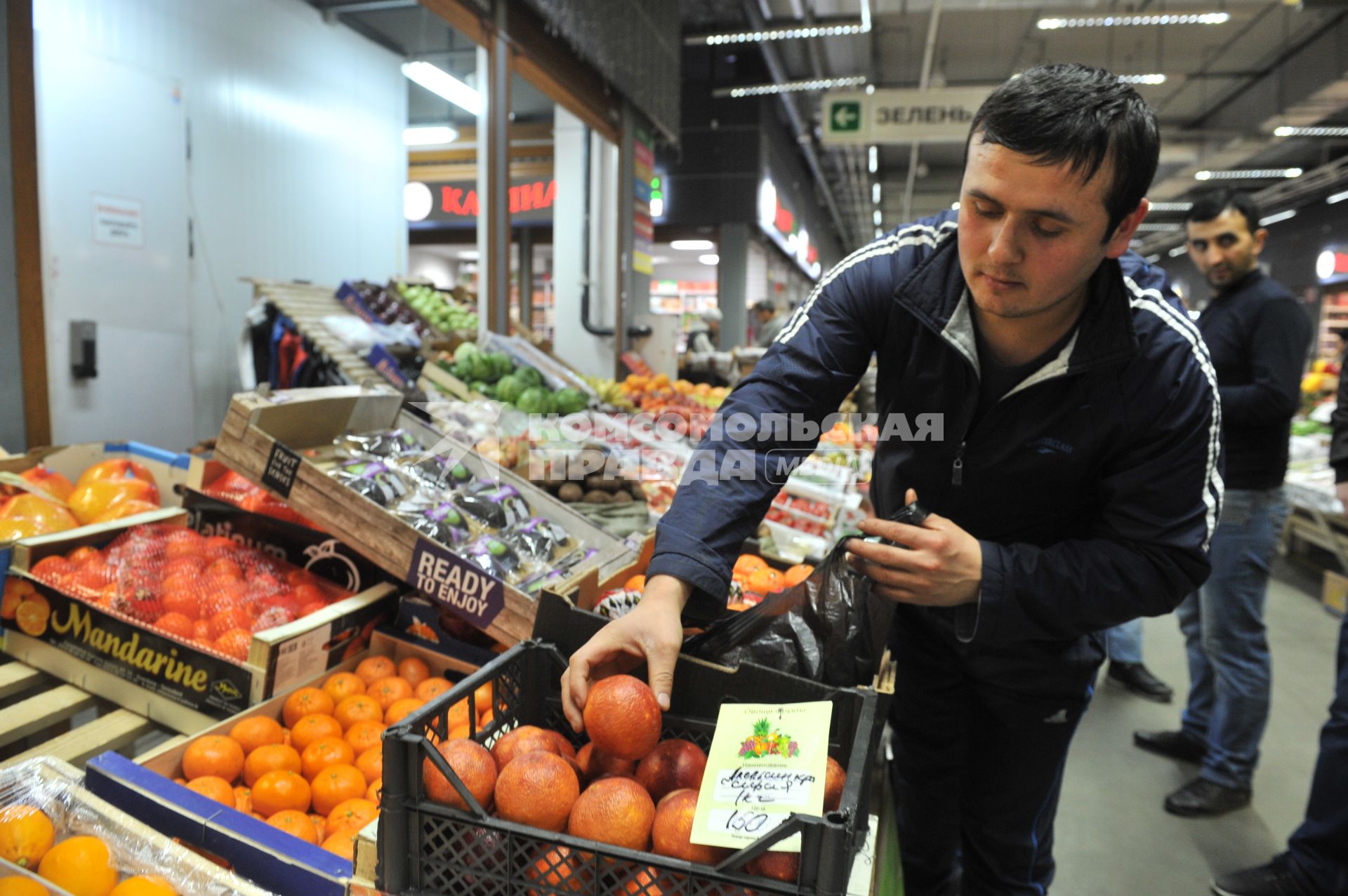 Москва.  Продавец у лотка с сирийскими апельсинами.