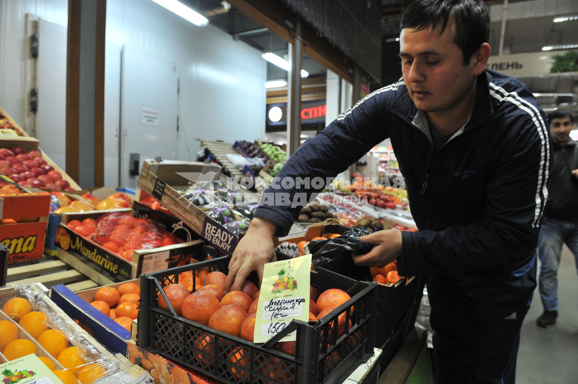 Москва.  Продавец у лотка с сирийскими апельсинами.