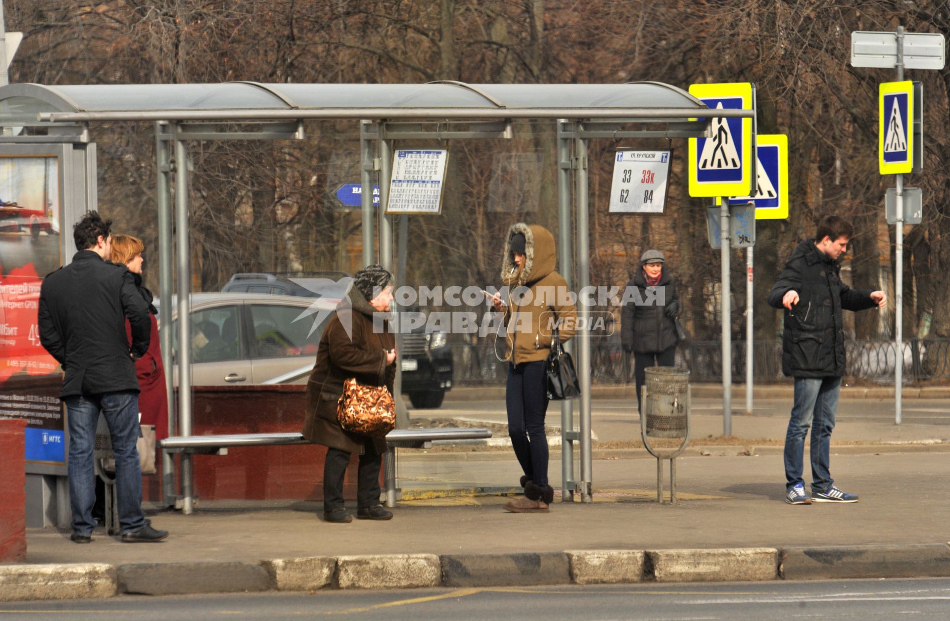 Москва.  Пассажиры на автобусной остановке.