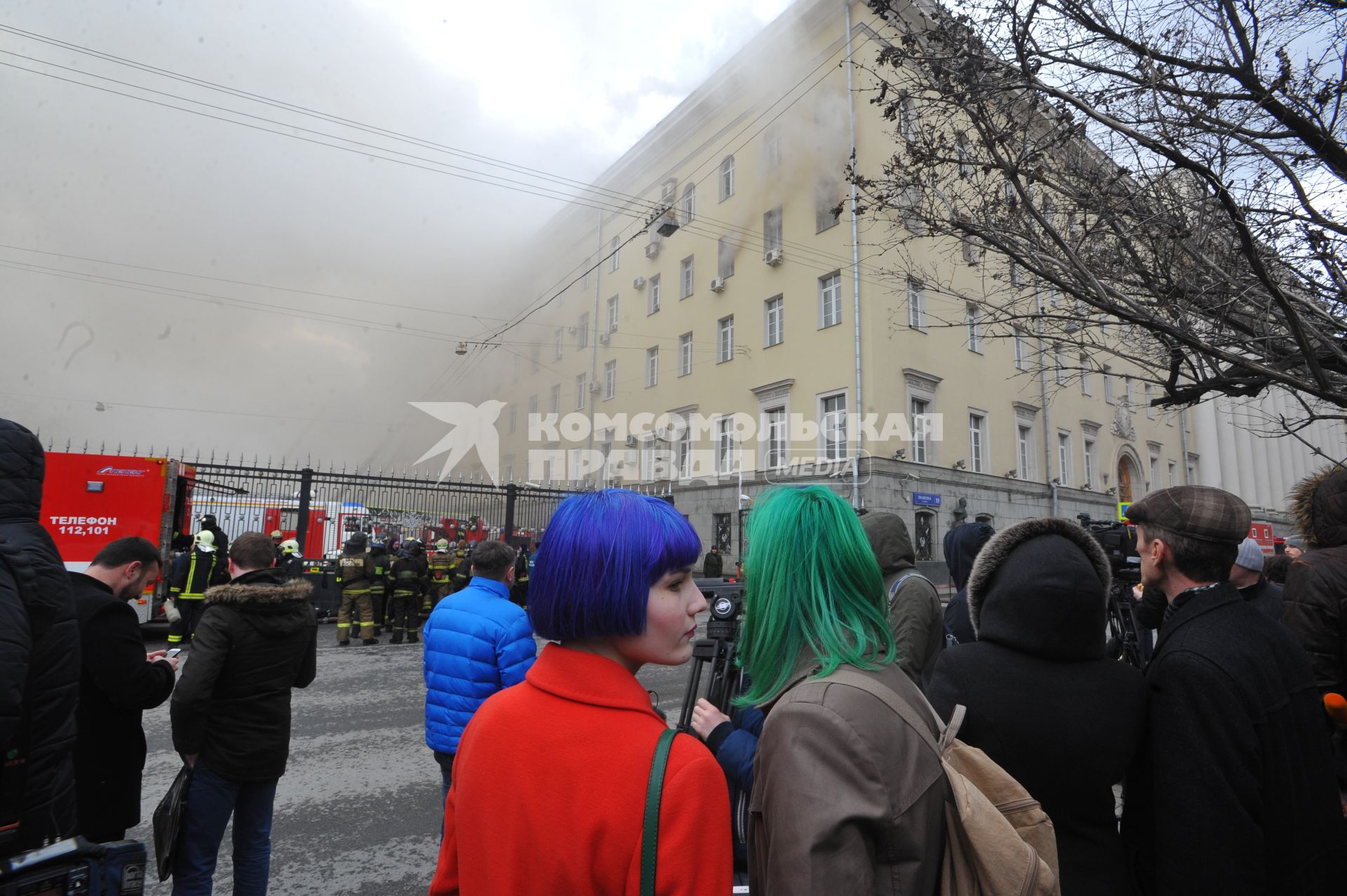 Москва.  Люди наблюдают за тушением пожара в здании Министерства обороны России на улице Знаменка.