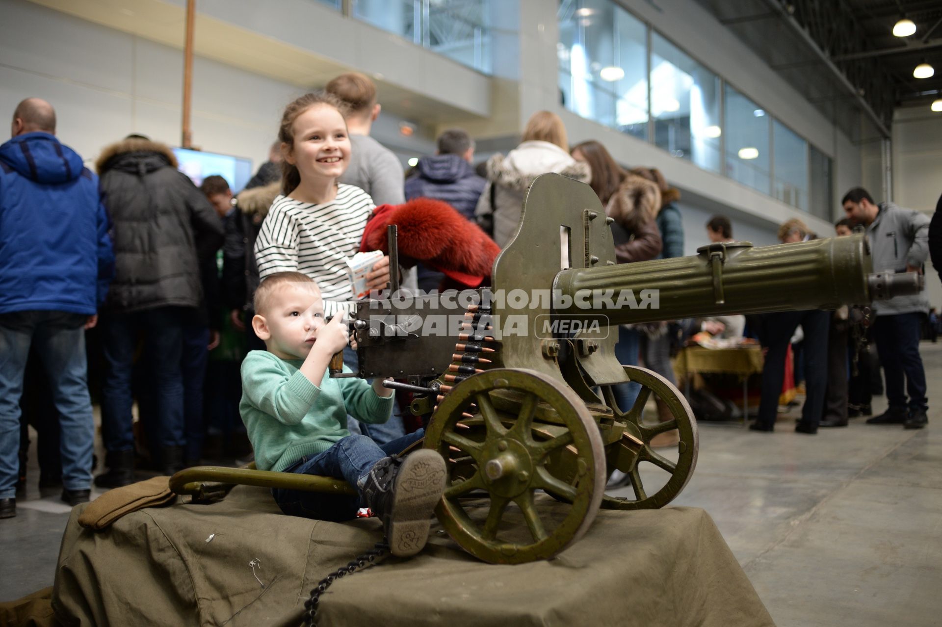 Москва. Дети у пулемета Максим на выставке исторической военной техники `Моторы Войны` в выставочном центре `Крокус Экспо`.