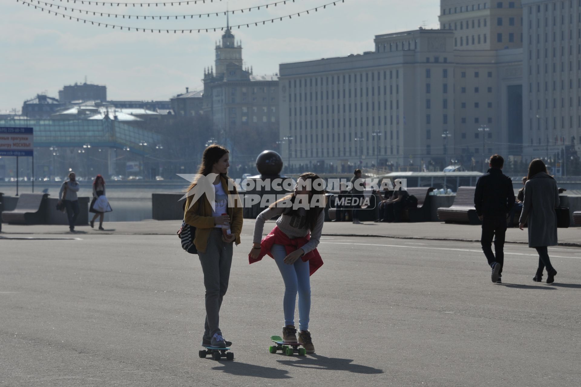 Москва.  Девушки катаются на скейтбордах на Пушкинской набережной Парка Горького.