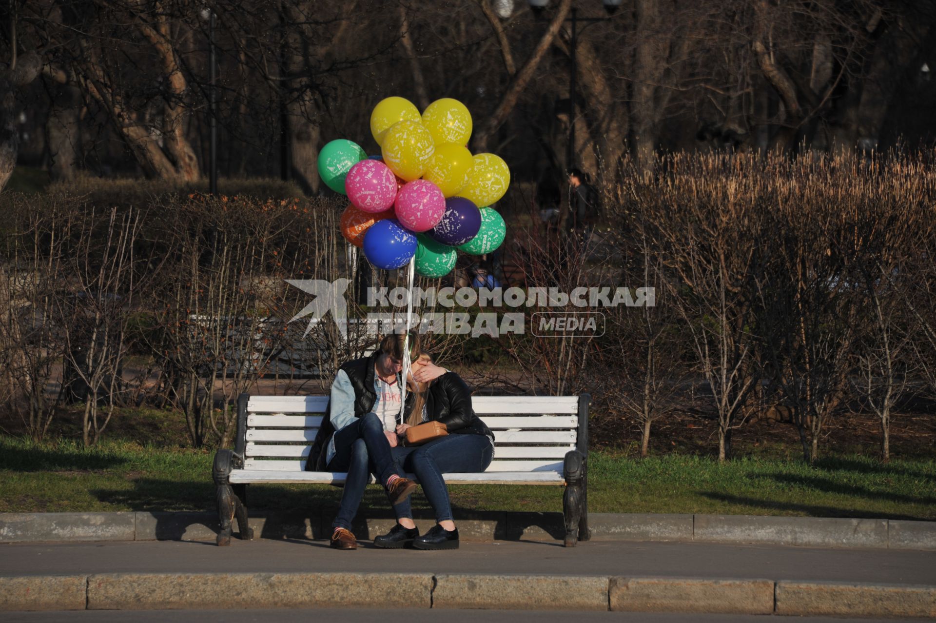 Москва. Влюбленная парана скамейке в парке.