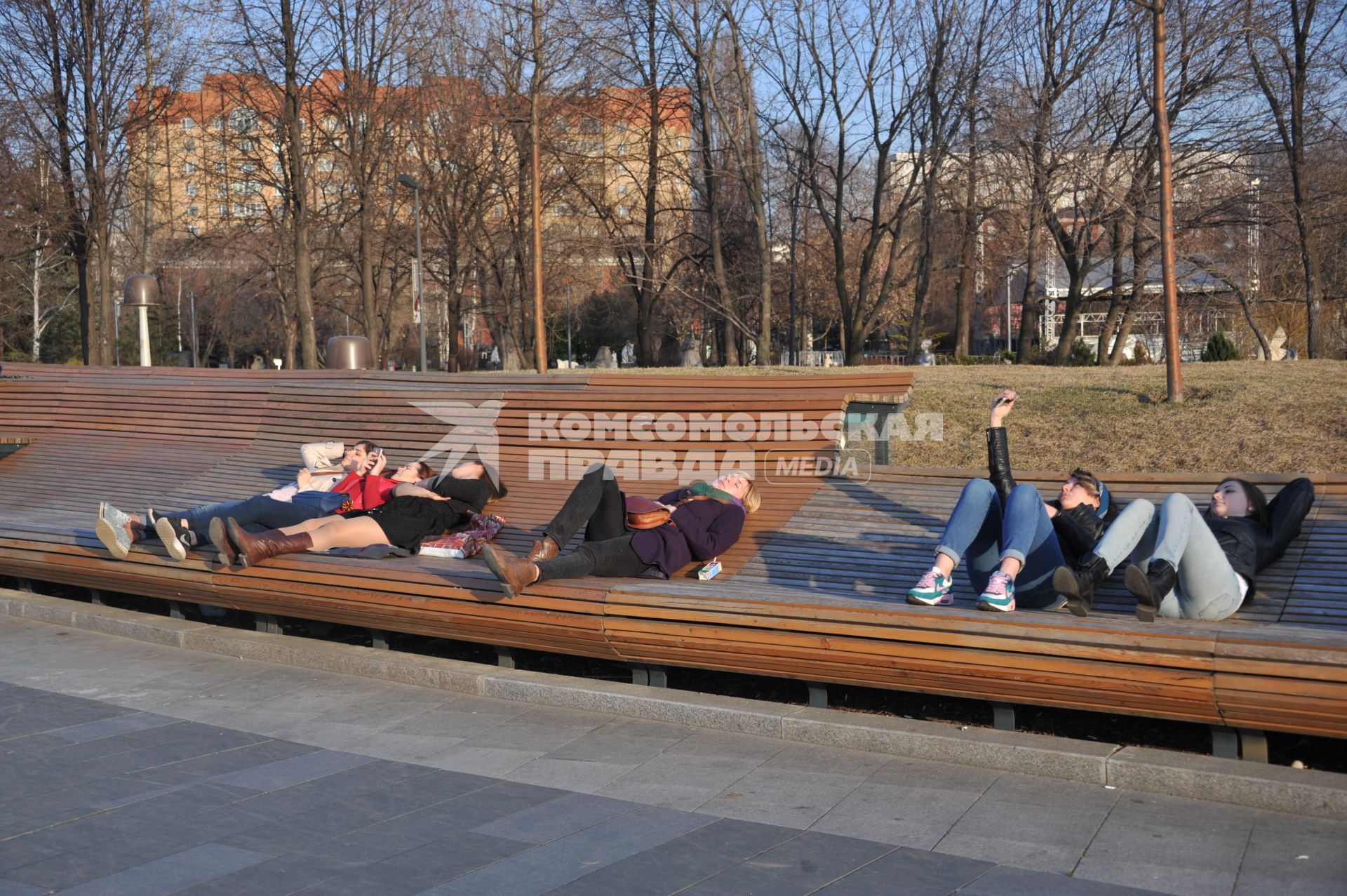 Москва.  Молодежь отдыхает и расслабляется на скамейках парка.