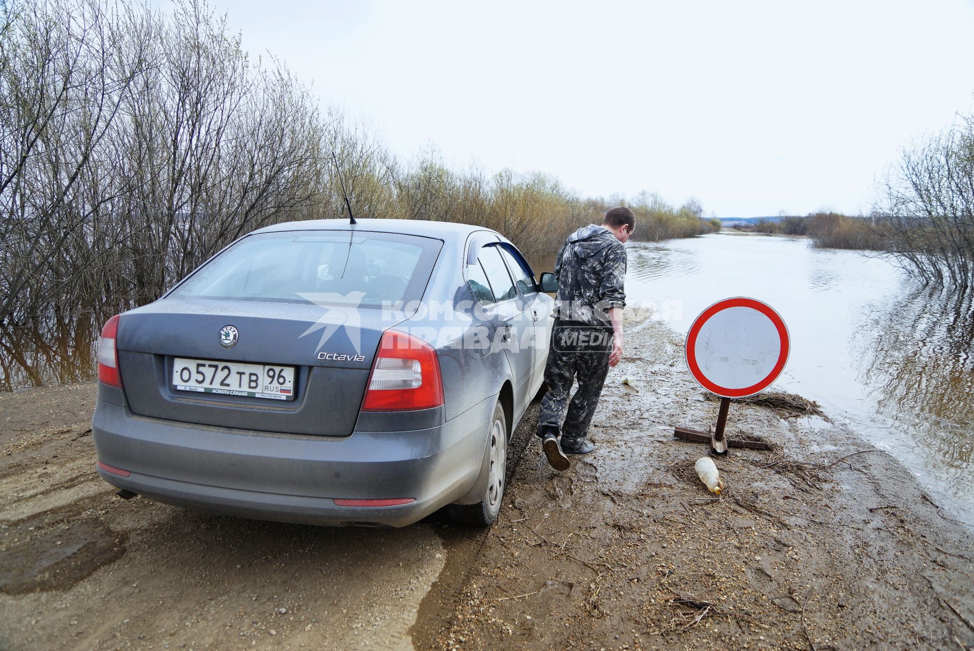 Свердловская область, деревня Махнево. Водитель у дороги затопленой во время разлива реки Тагил.