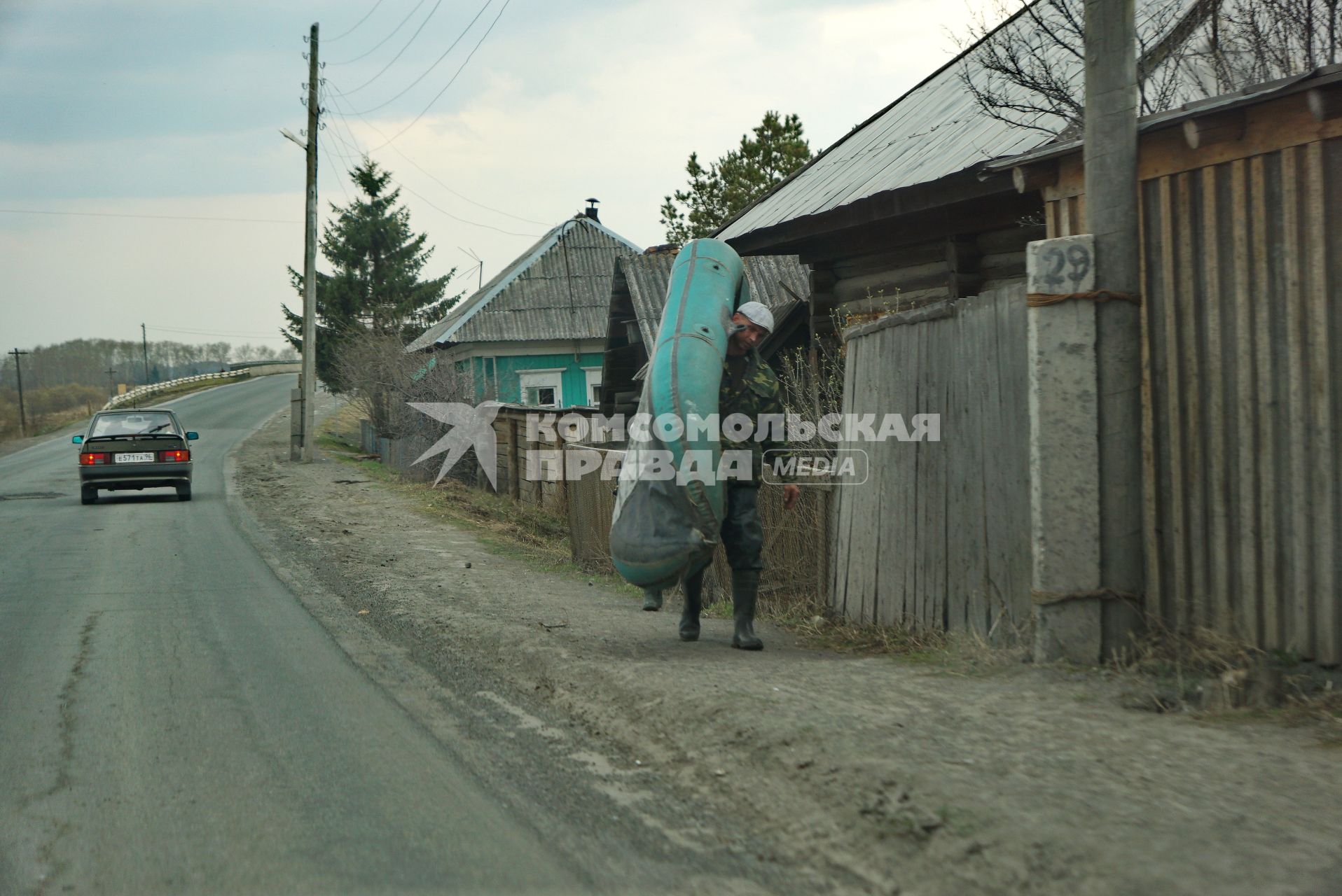 Свердловская область, г.Ирбит. Мужчина несет резиновую лодку во время разлива рек Ирбит и Ница.