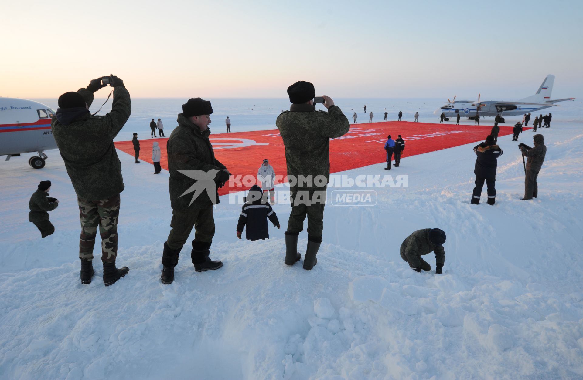 Северный полюс. Полярники фотографируют копию  знамени Победы , которую доставили и развернули на Северном полюсе делегаты миротворческой миссии `Самое большое знамя Победы`