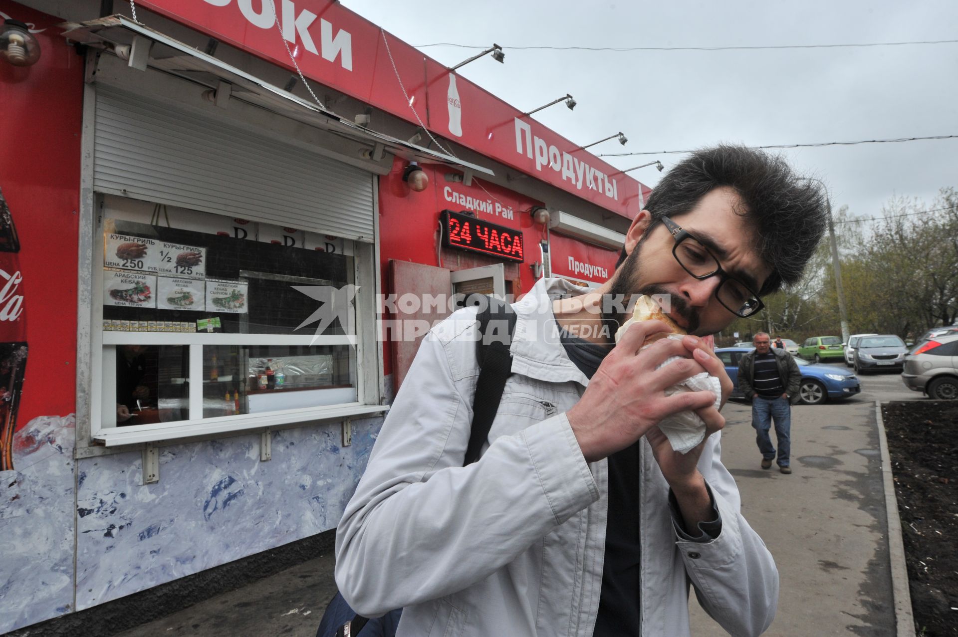 Москва. Молодой человек ест шаурму.