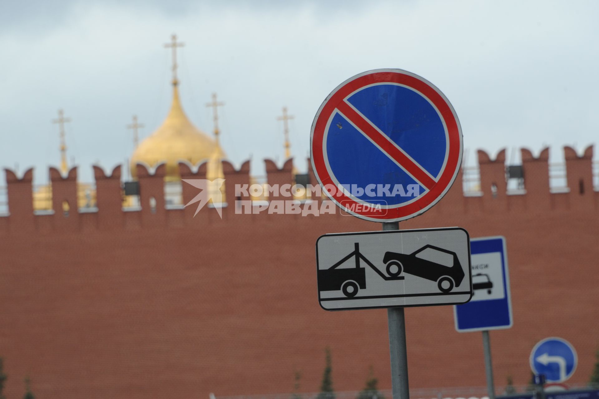 Москва. Дорожный знак стоянка запрещена и табличка работы эвакуатора у стен Кремля.