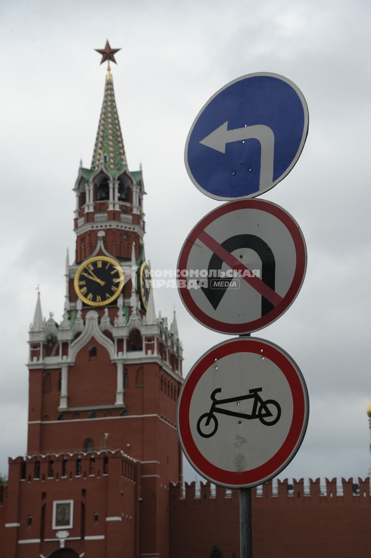 Москва. Дорожные знаки -  поворот налево , разворот запрещен и запрет велосипедистам у Спасской башни Кремля.