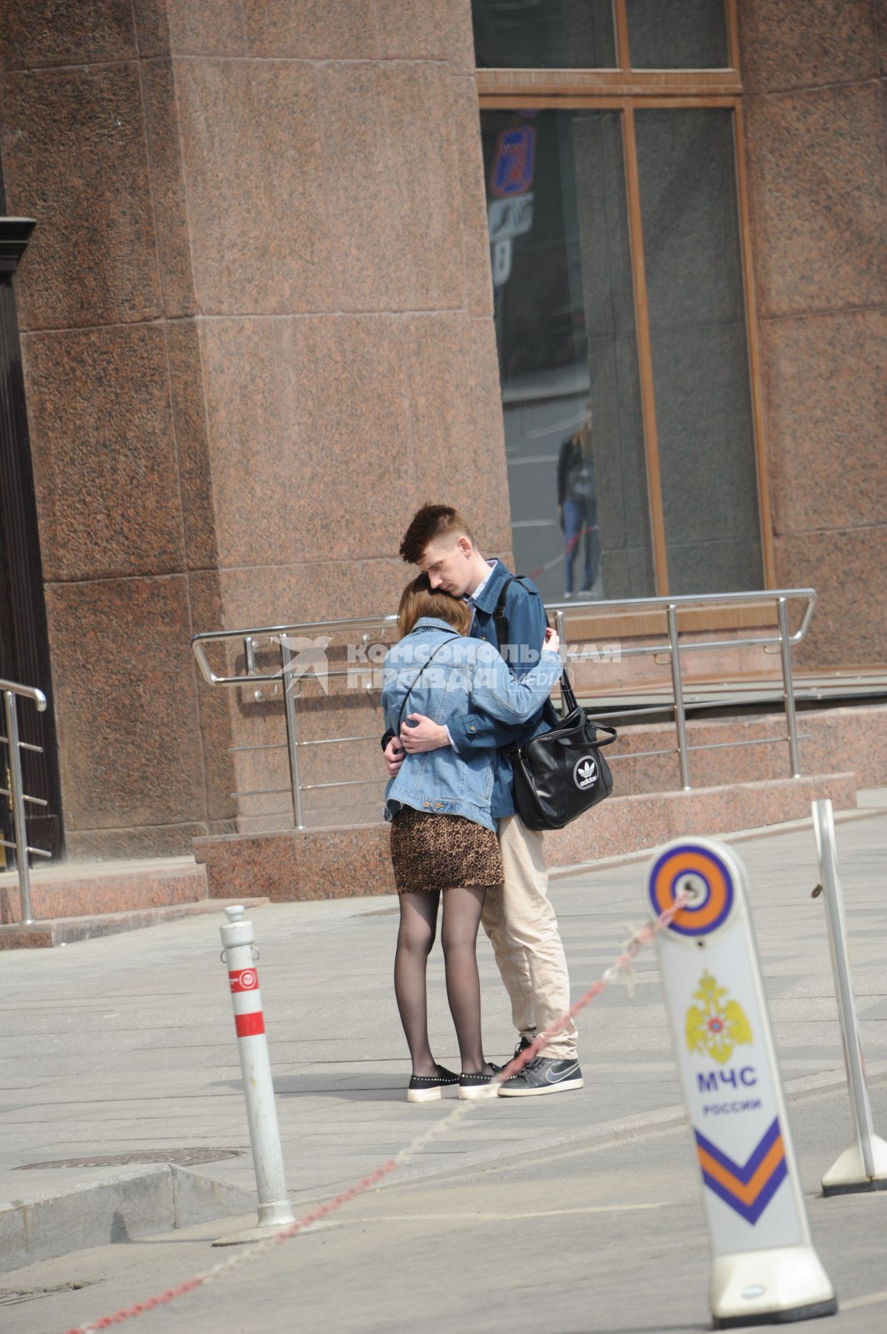 Москва.   Молодой человек обнимает девушку на улице города.