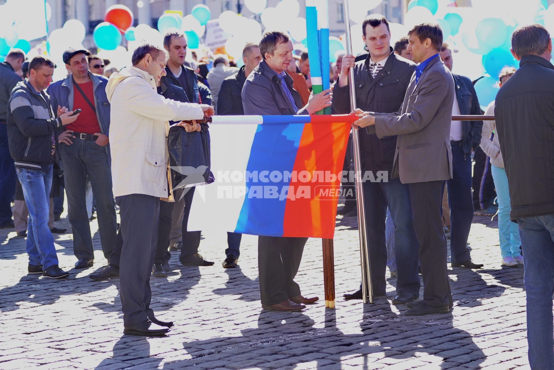 Екатеринбург. Празднование дня весны и труда 1 мая. Участники демонстрации сворачивают флаг России после шествия