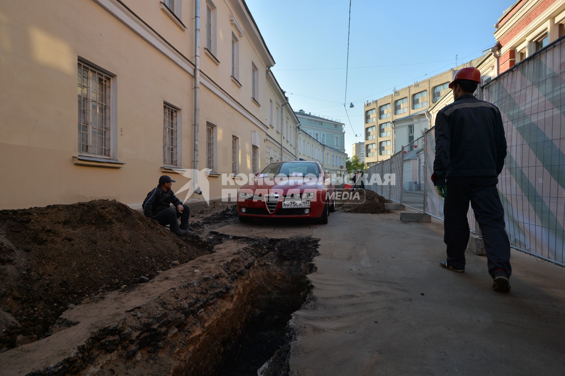 Москва. Машина в  Калашном  переулке  оказалась зажата между двумя траншеями и забором из-за внезапно начавшегося ремонта.