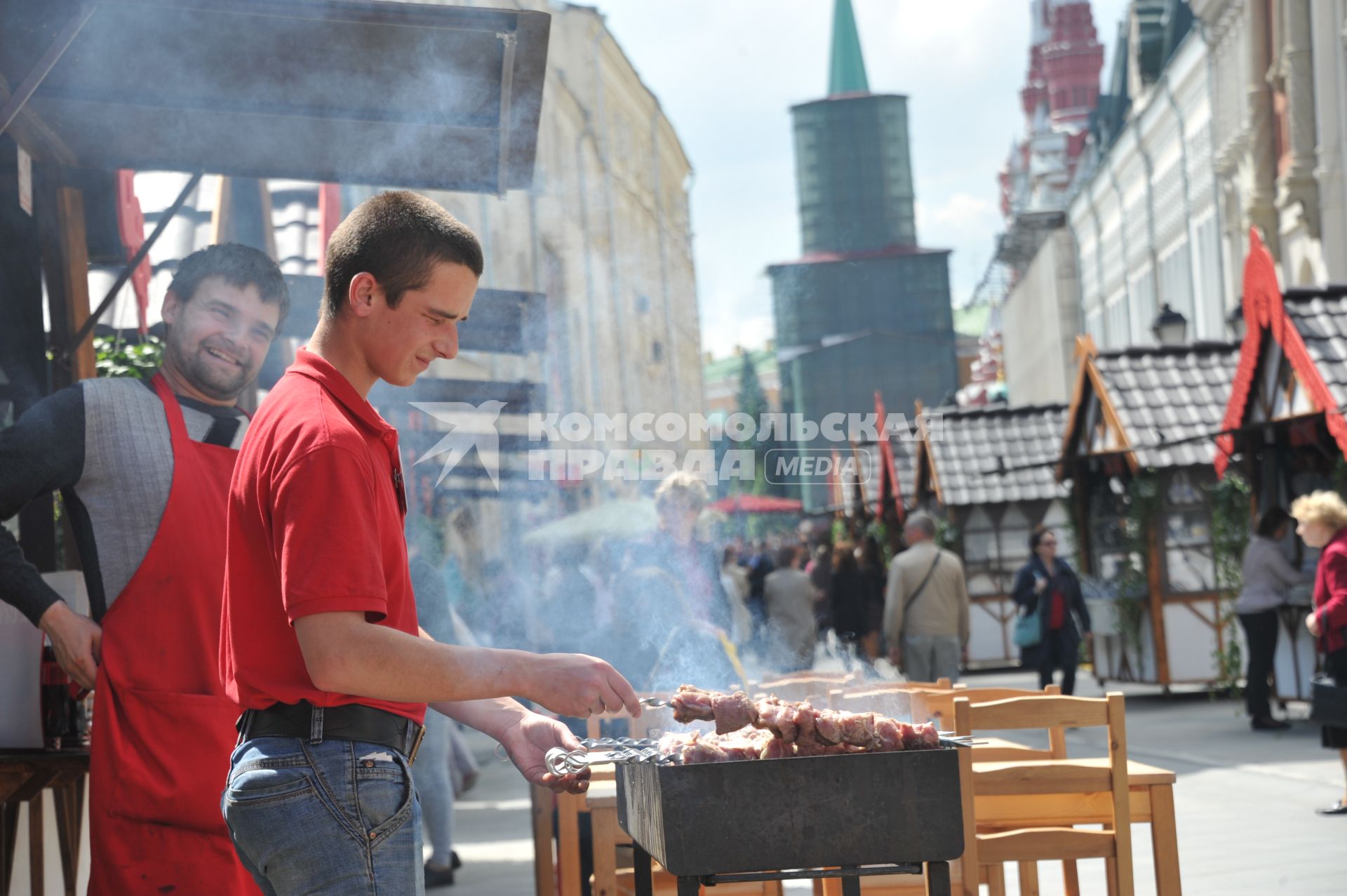 Москва. Мужчина жарит шашлык во время ярмарки  на Никольской улице.