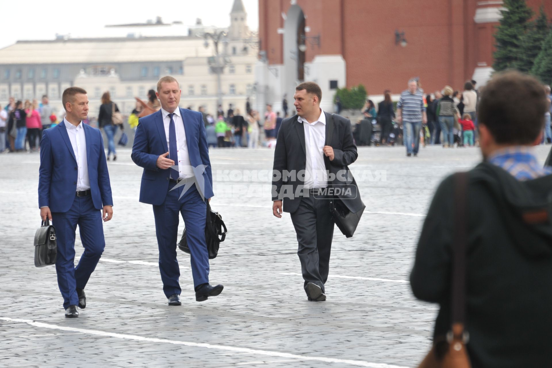 Москва.  Мужчины прогуливаются по  Красной площади в районе Никольской улицы.