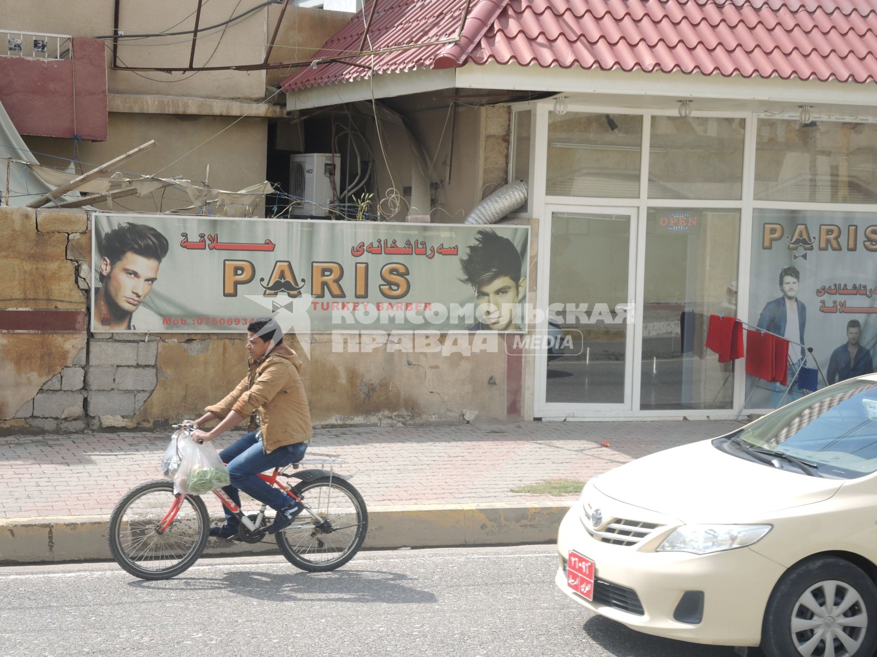 Ирак. Эрбиль. Жизнь за линией фронта. Мальчик на велосипеде на улице города.