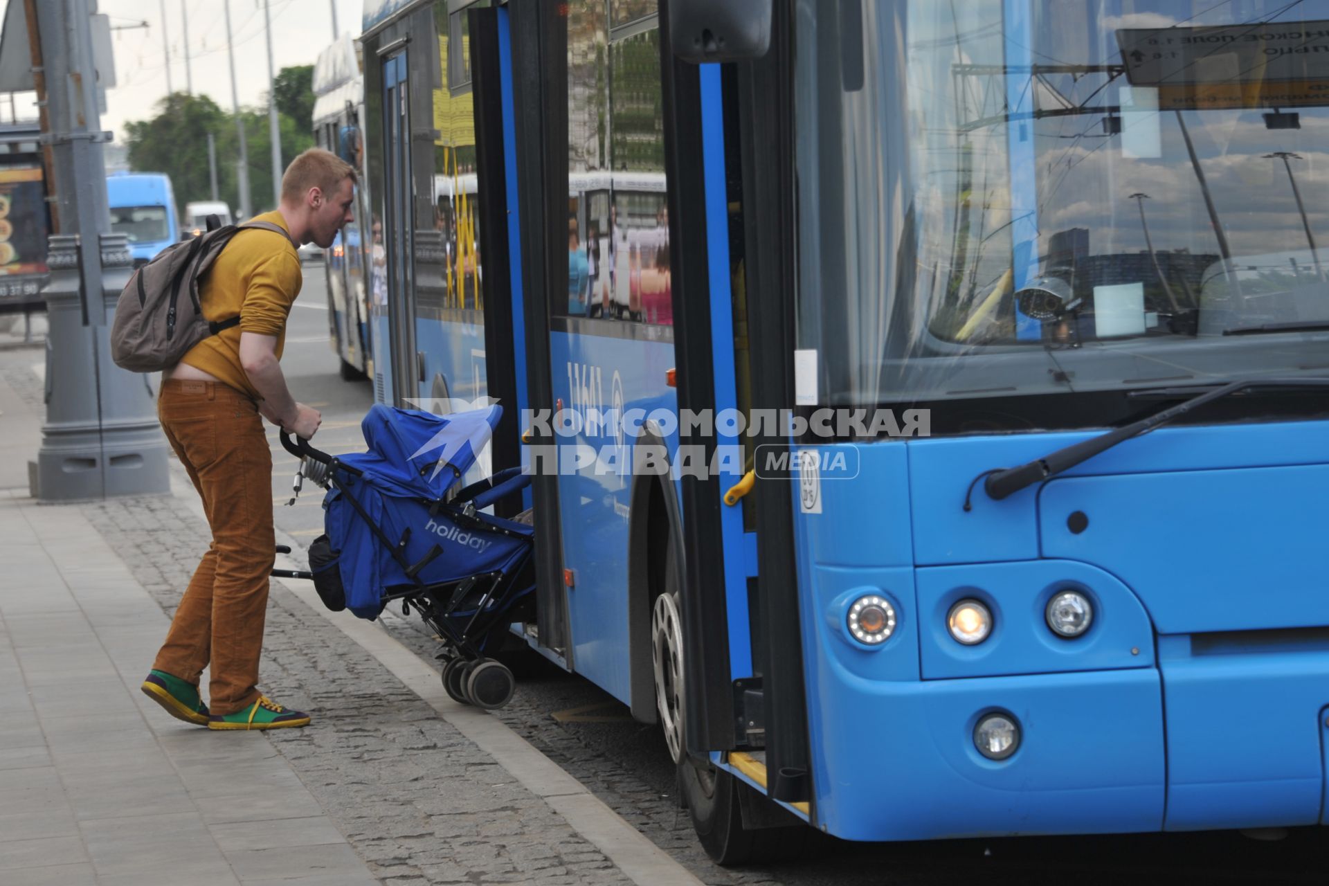 Москва.   Мужчина с детской коляской заходит в автобус.