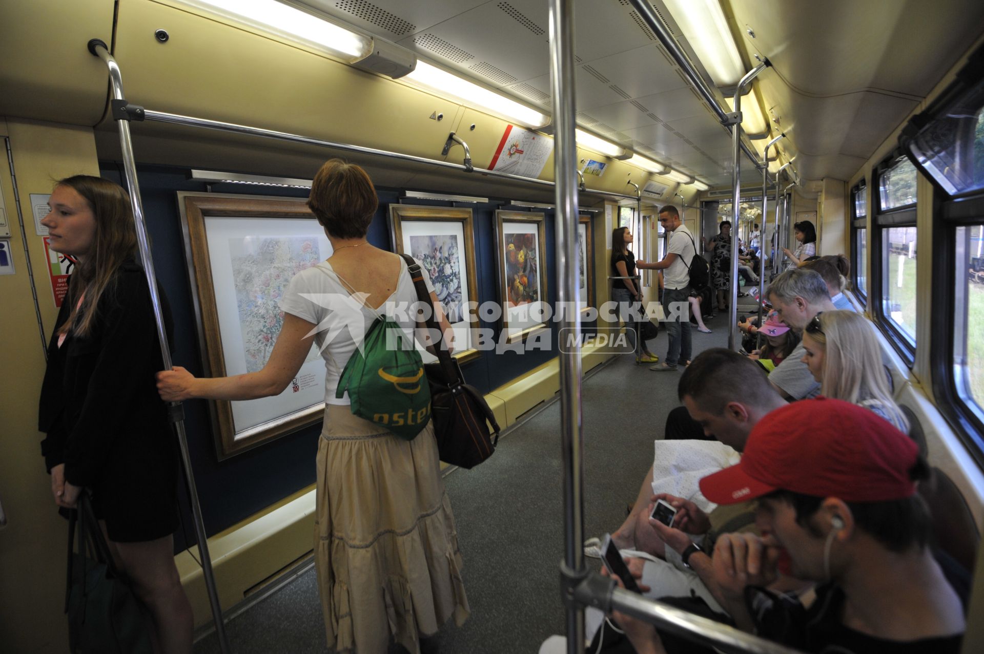 Москва. Пассажиры метрополитена в поезде `Акварель` с обновленной экспозицией `Мастера Строгановской школы`.